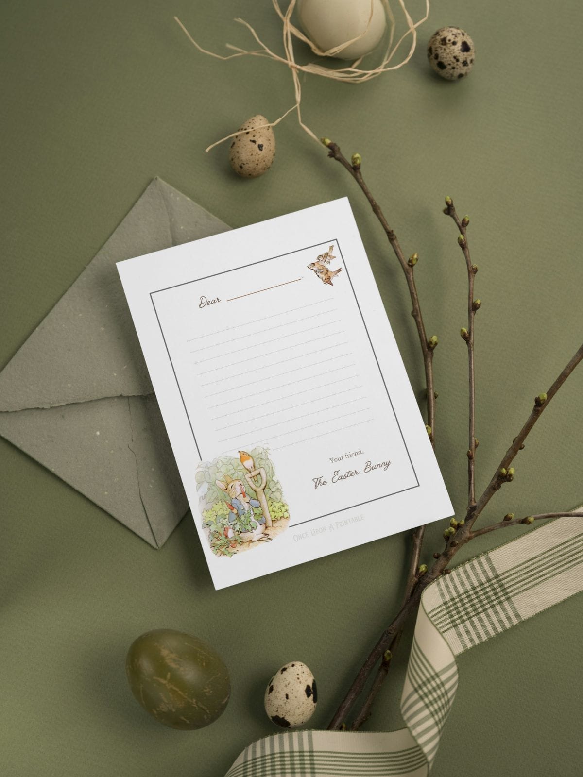Blank Easter Bunny Letter featuring Peter Rabbit illustrations sitting on a beautiful green table cloth, with eggs and ribbon.