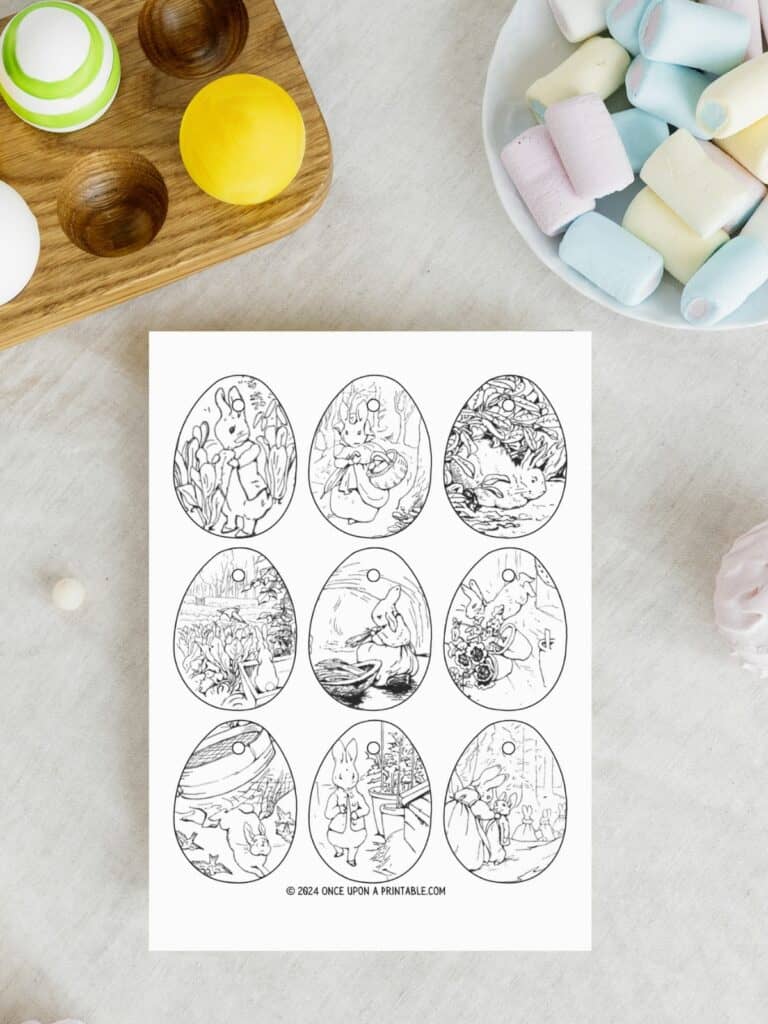 Peter Rabbit and friends Easter egg ornaments laying on a marbletop table with candy and eggs.