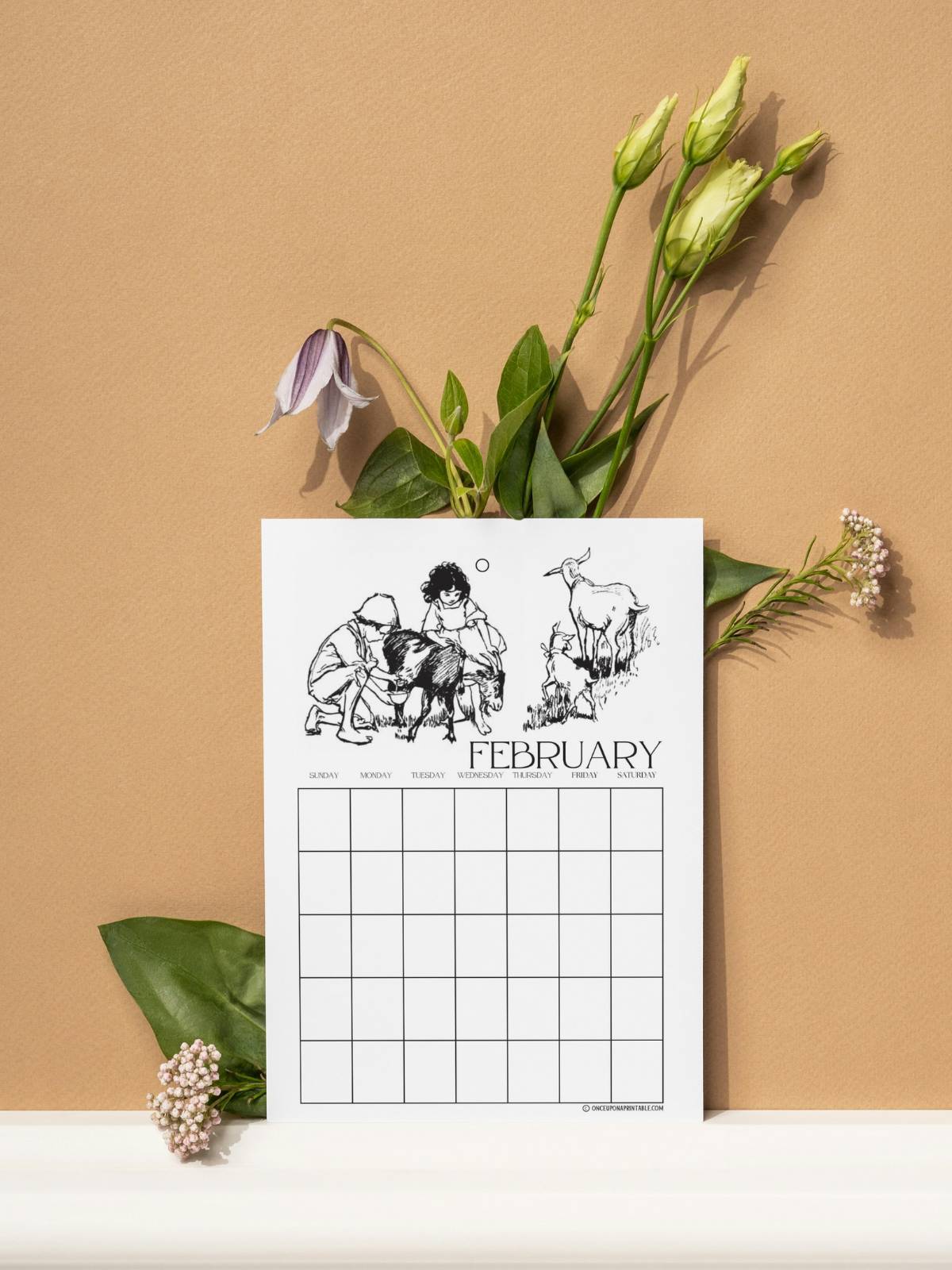 Heidi illustrated calendar pages by Jessie Willcox Smith sitting on an orange wall with a selection of flowers.