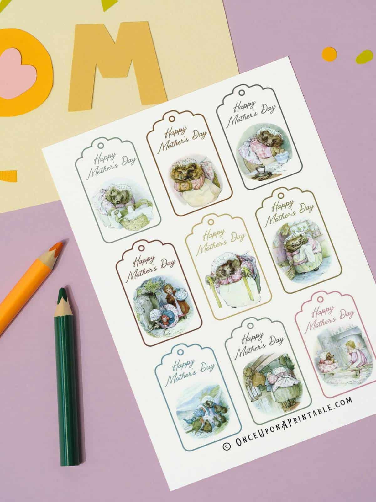A sheet of Mrs. Tiggy-Winkle Mother's Day gift tags next to colored pencils.