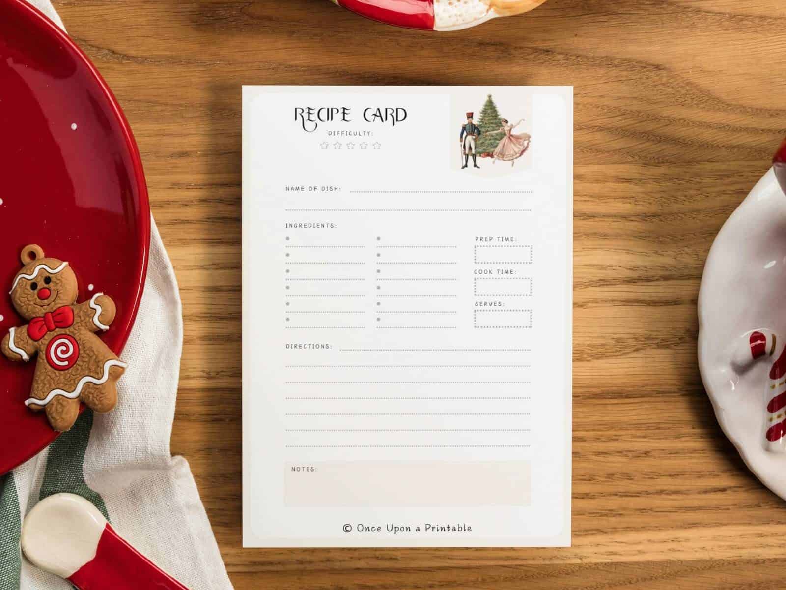 Nutcracker themed recipe card sitting on a table next to plates and a gingerbread ornament.