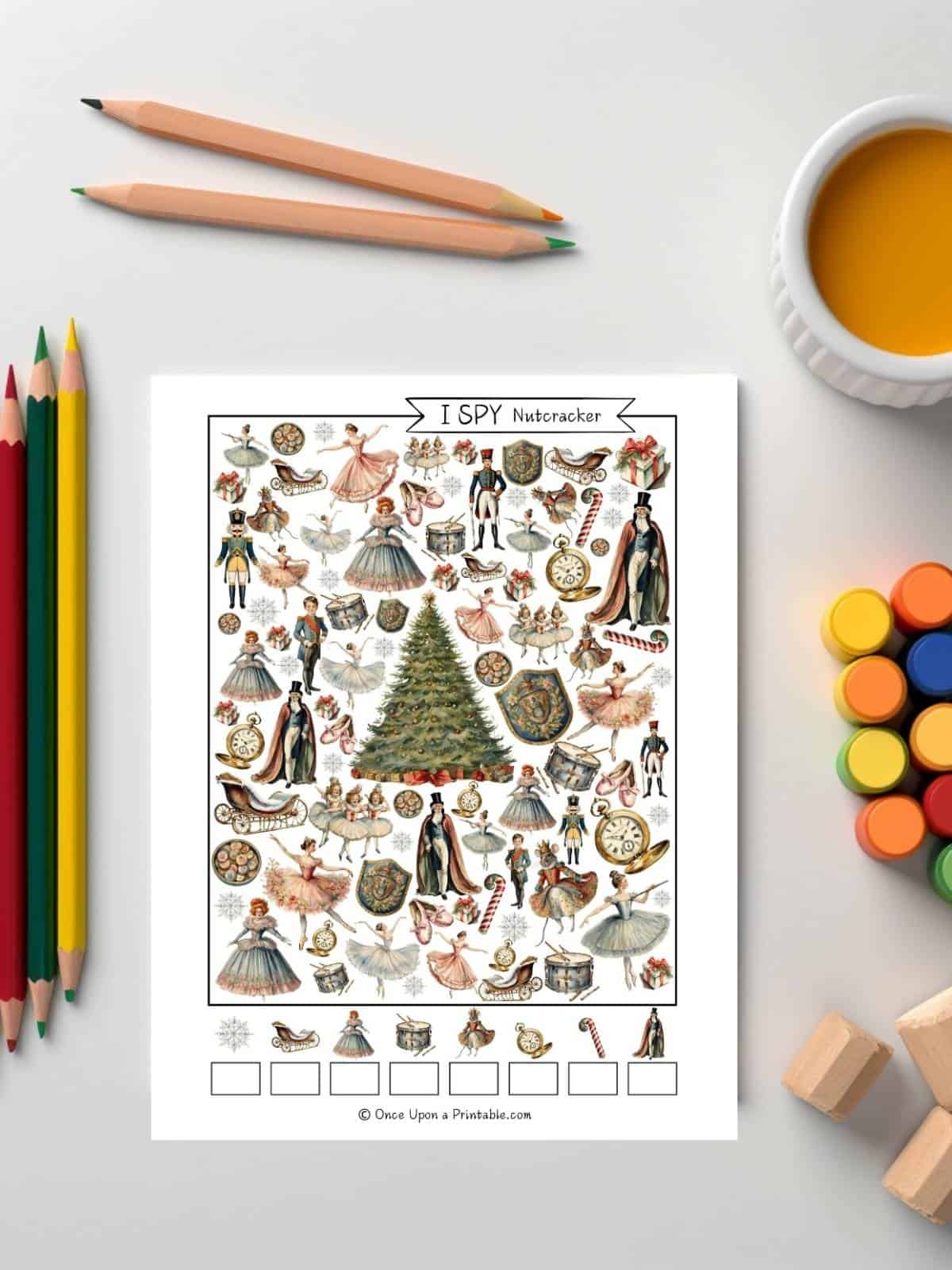 Nutcracker themed watercolor graphics creating a fun "I spy" printable activity sitting on a table with colored pencils and paints.