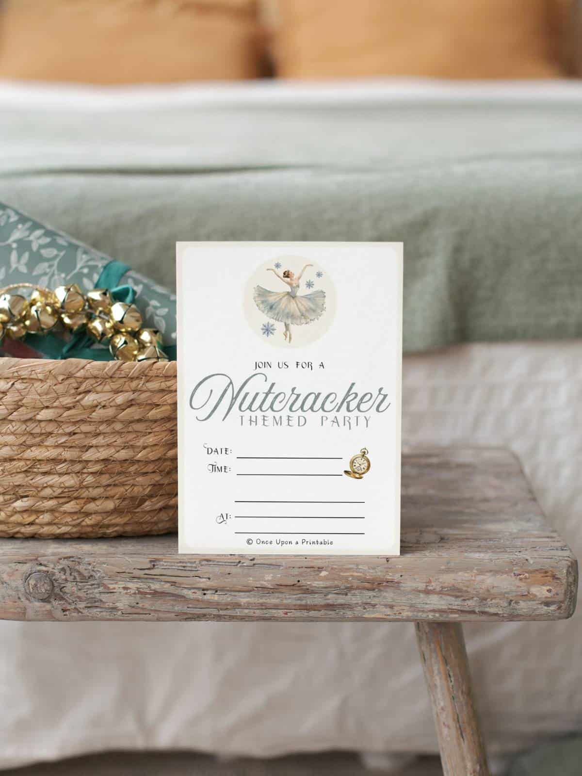 The Waltz of the Snowflakes Nutcracker-themed party invitation sitting on a wooden bench next to a bed,