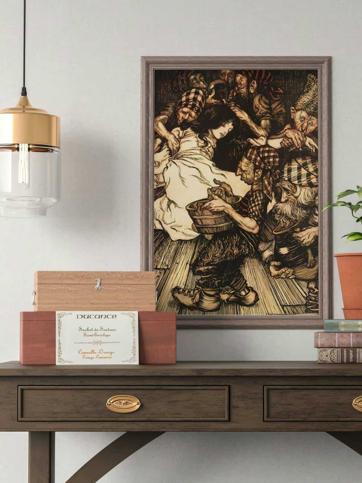 Arthur Rackham's illustration of "Snowdrop" or Snow White, a Brother's Grimm fairy tale. Framed and displayed aboce a wooden desk with decor and books.