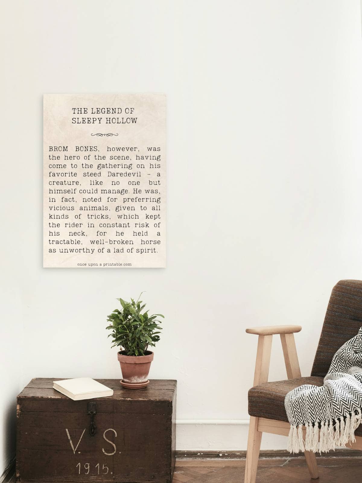 Framed Sleepy Hollow quote displayed above an old trunk with a houseplant on it. 