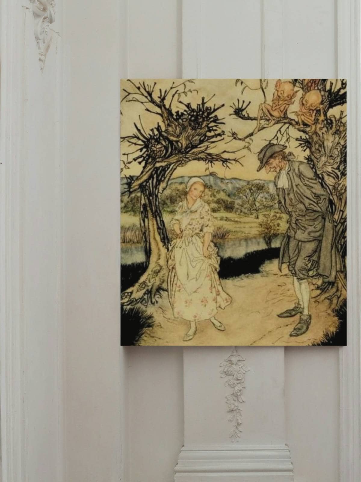 Ichabod Crane and Katrina Van Tassel illustrated print by Arthur rackham hanging on a wall.
