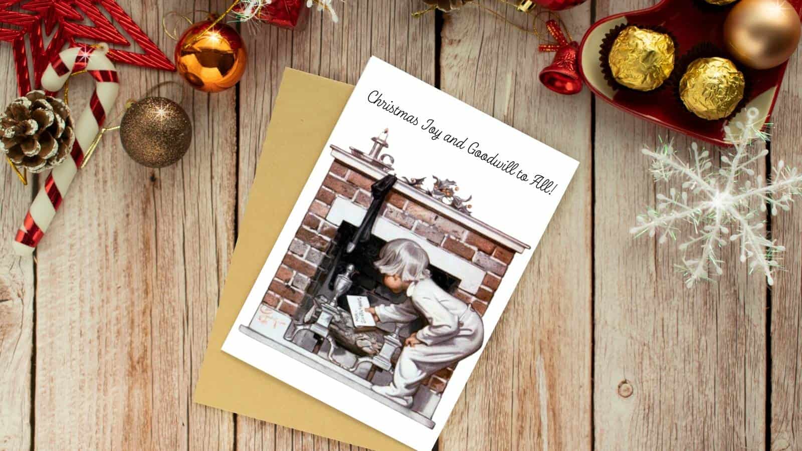 J C Leyendecker's vintage illustration of a little boy putting a letter to santa up the chimney standing by a fireplace hearth. The card is displayed on a wooden surface with Christmas tree ornaments.