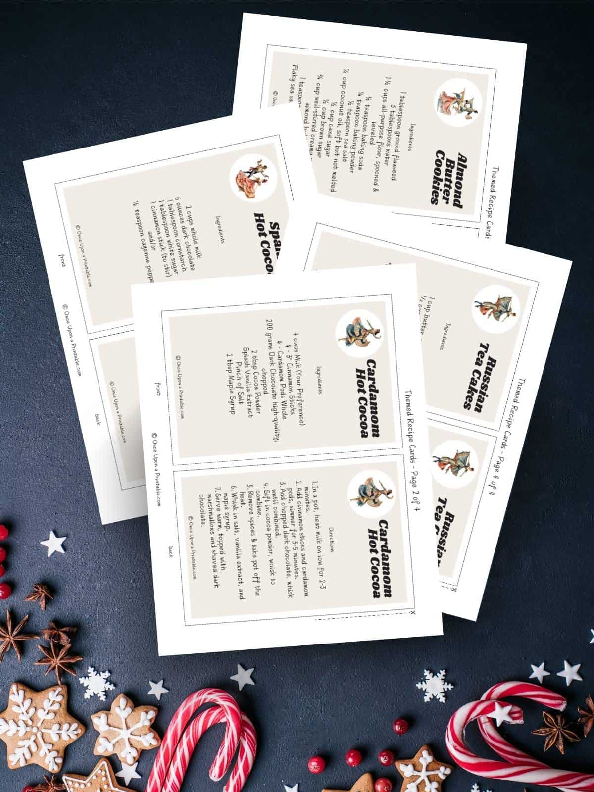 Nutcracker themed recipes for the advent board game activities printed out and displayed on a dark blue background with candy canes and gingerbread cookies.