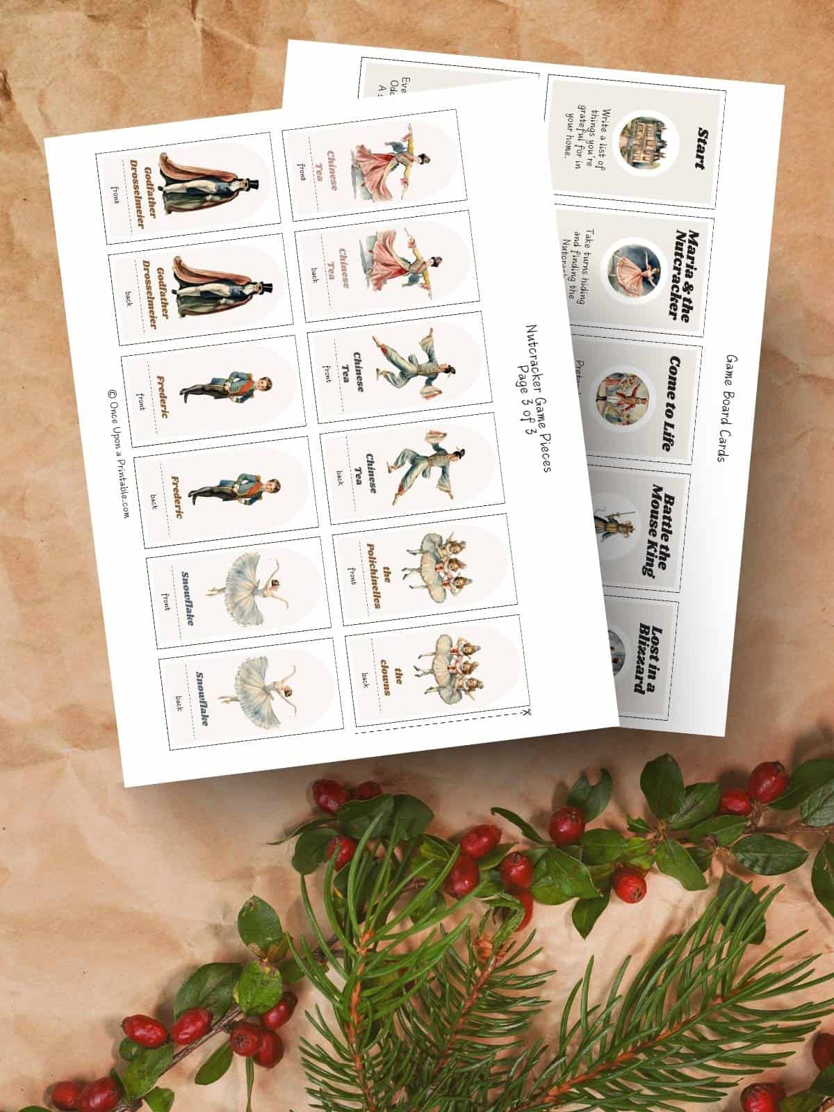 Nutcracker themed game pieces and game cards for an advent board game displayed on brown craft paper and garland with red berries.