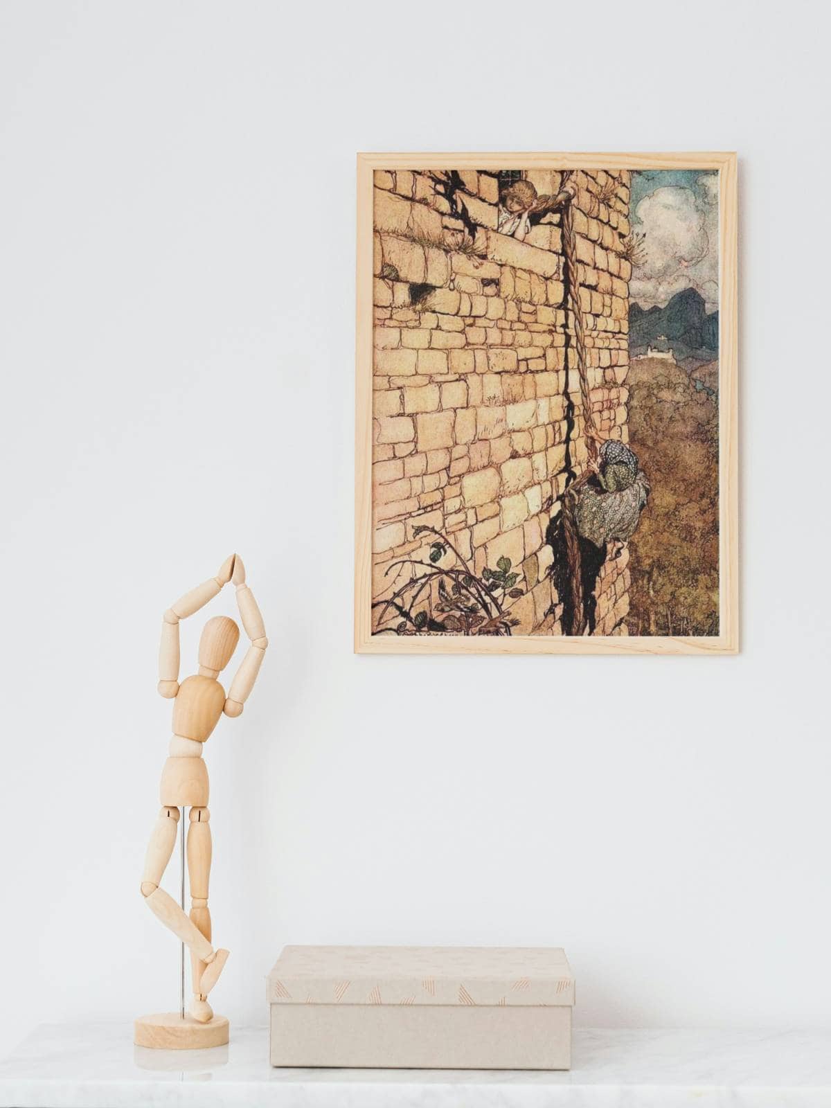 Rapunzel illustrated by Arthur Rackham from the Brother's Grimm fairy tales, framed and displayed on a wall next to a wooden drawing tool.