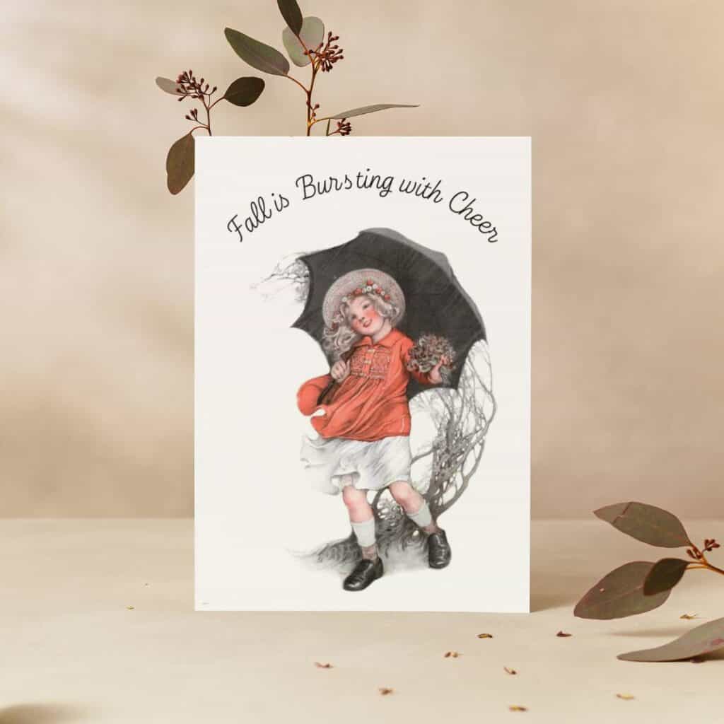 Girl with umbrella walking in the wind, illustrated by Sarah Stilwell-Weber a greeting card sitting on a vase with dried flowers.