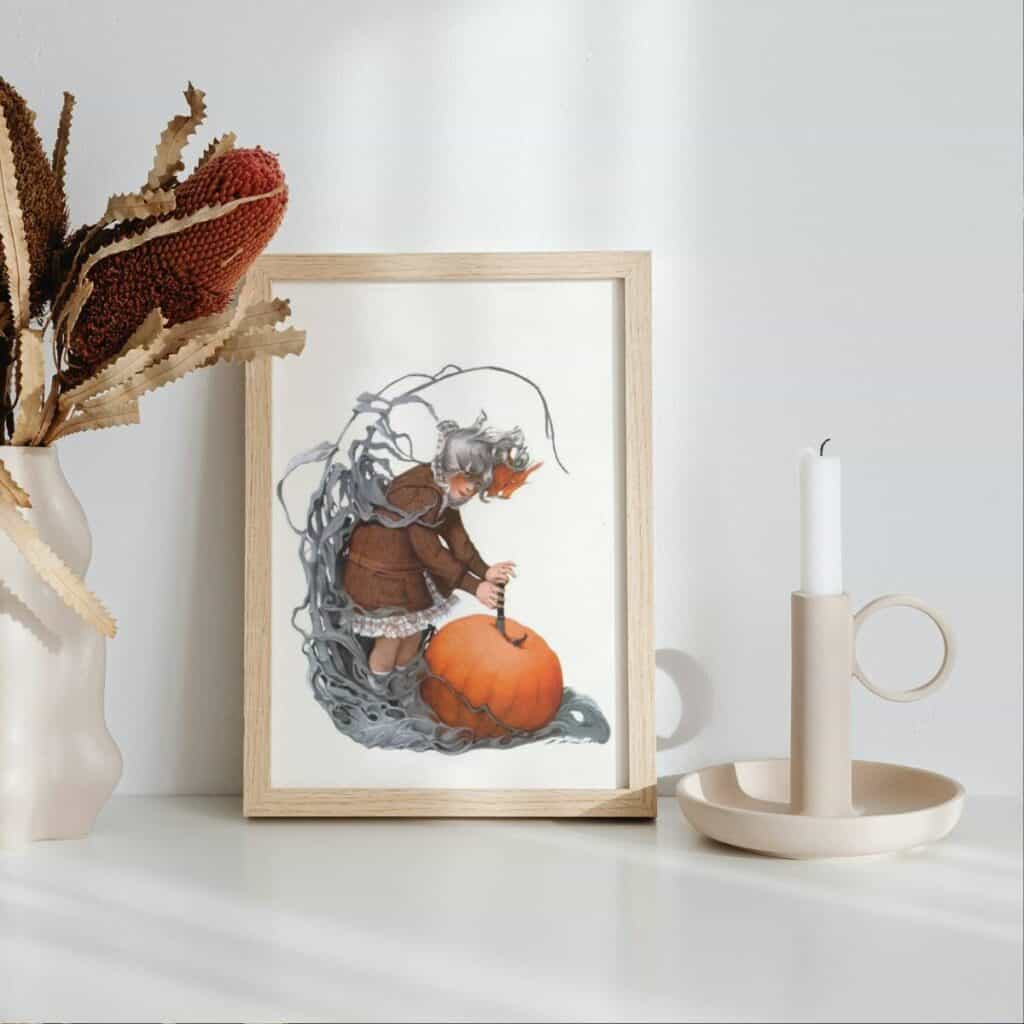 An illustration of a girl holding onto a large pumpkin, framed sitting next to a candle stick and a vase full of dried flowers.