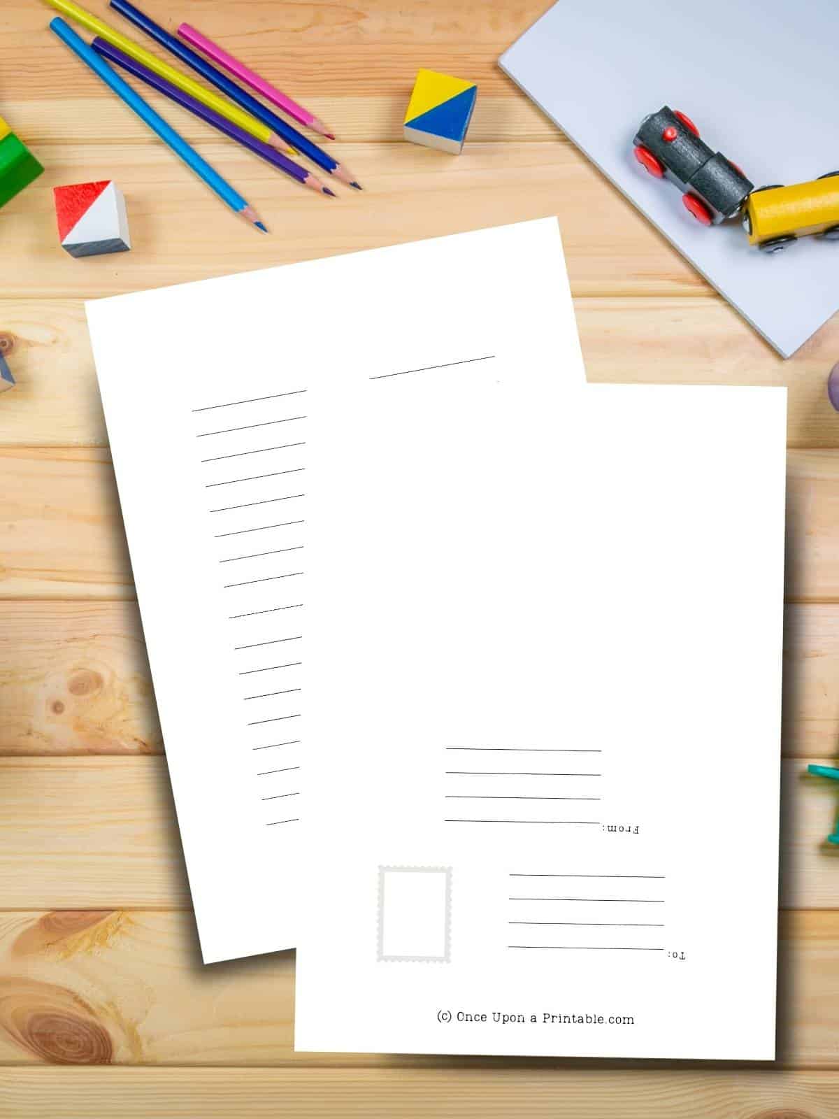 Stationary double-sided print options of extra writing and a mailing label printed out and sitting on a wooden table with coloring elements.