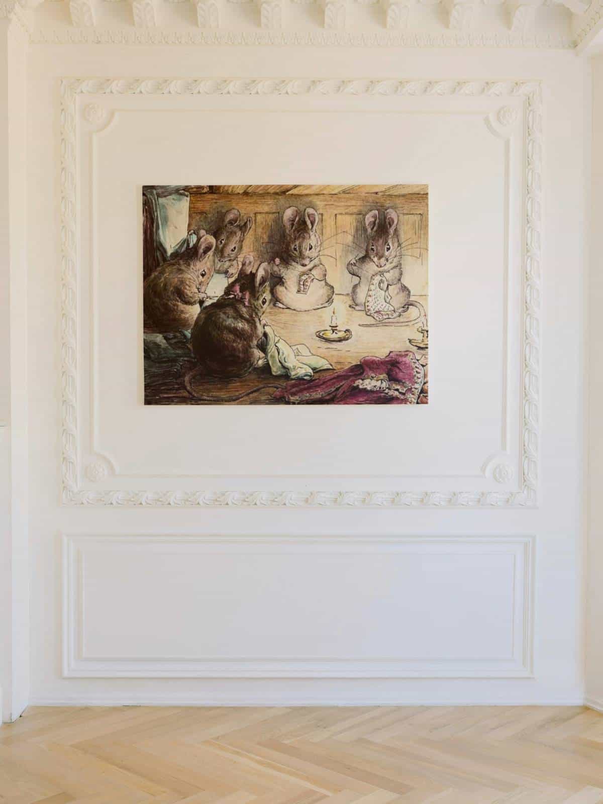 The Tailor of Gloucester illustration of mice faithfully sewing by candlelight displayed on a lovely cream wall.