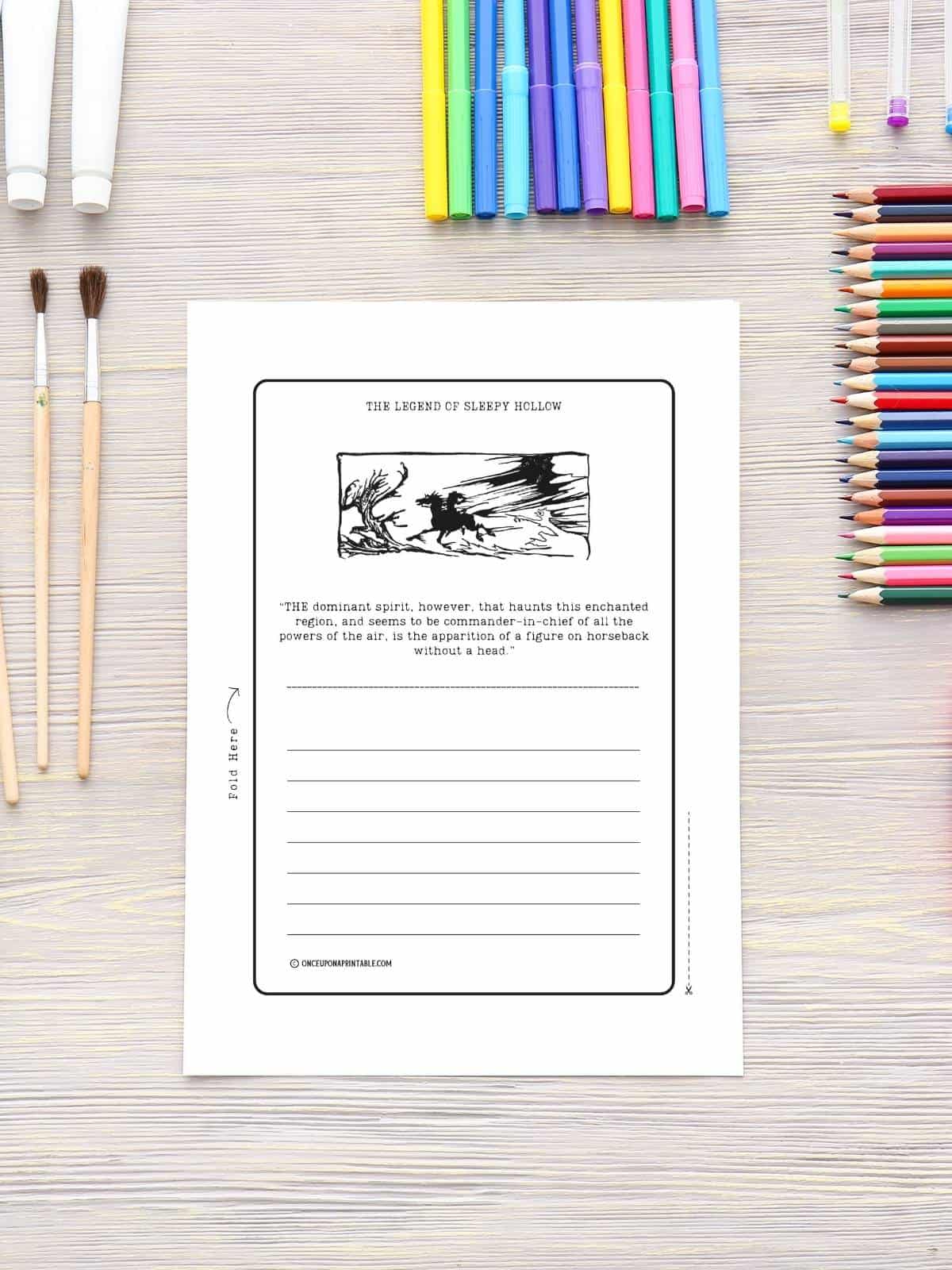 The legend of Sleepy Hollow headless horseman illustration in black and white on a stationary paper sitting next to coloring pencils.