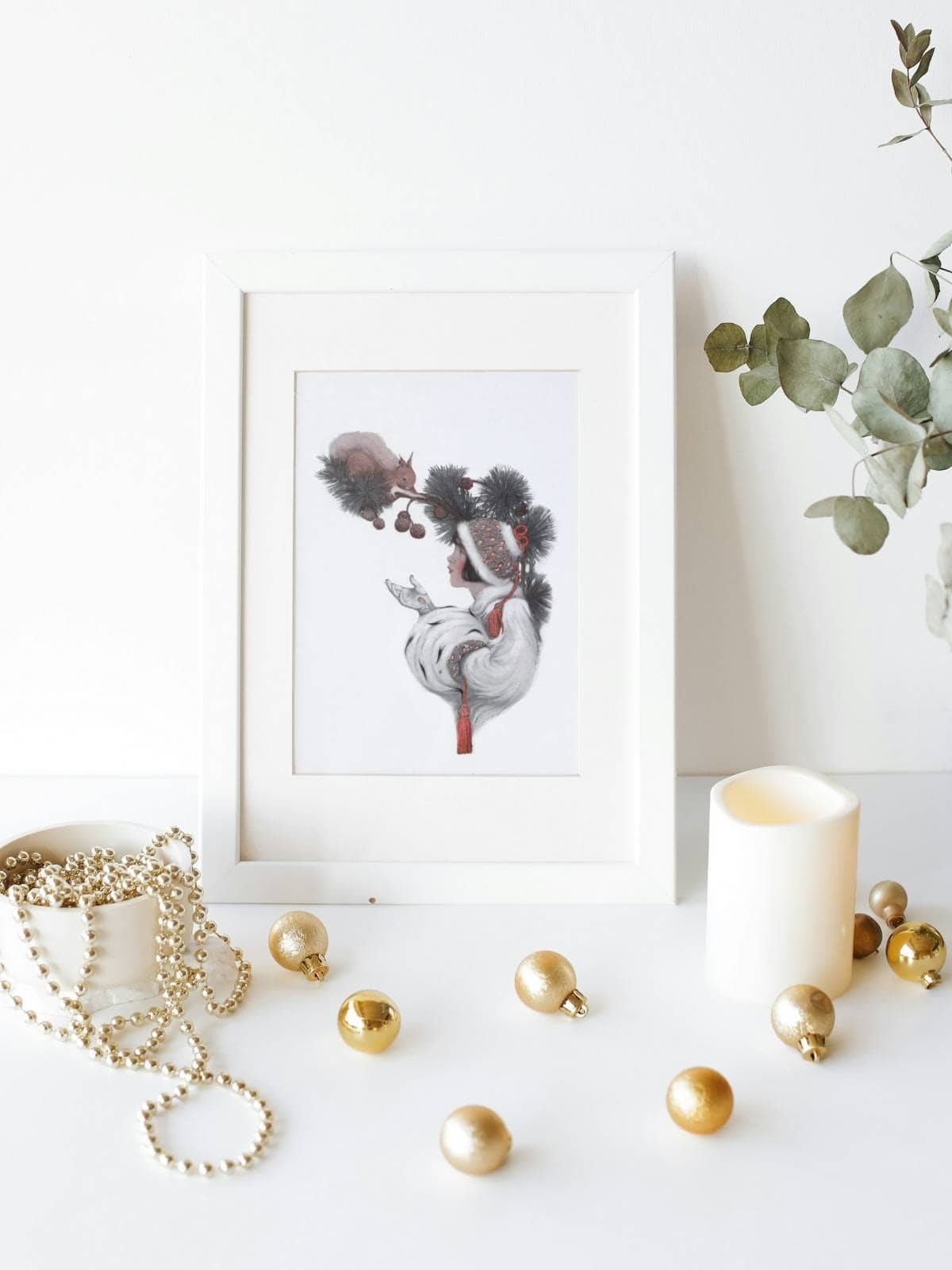 Vintage illustration of a woman feeding squirrels in a tree, in a white frame by golden balls and a jewelry trinket box.