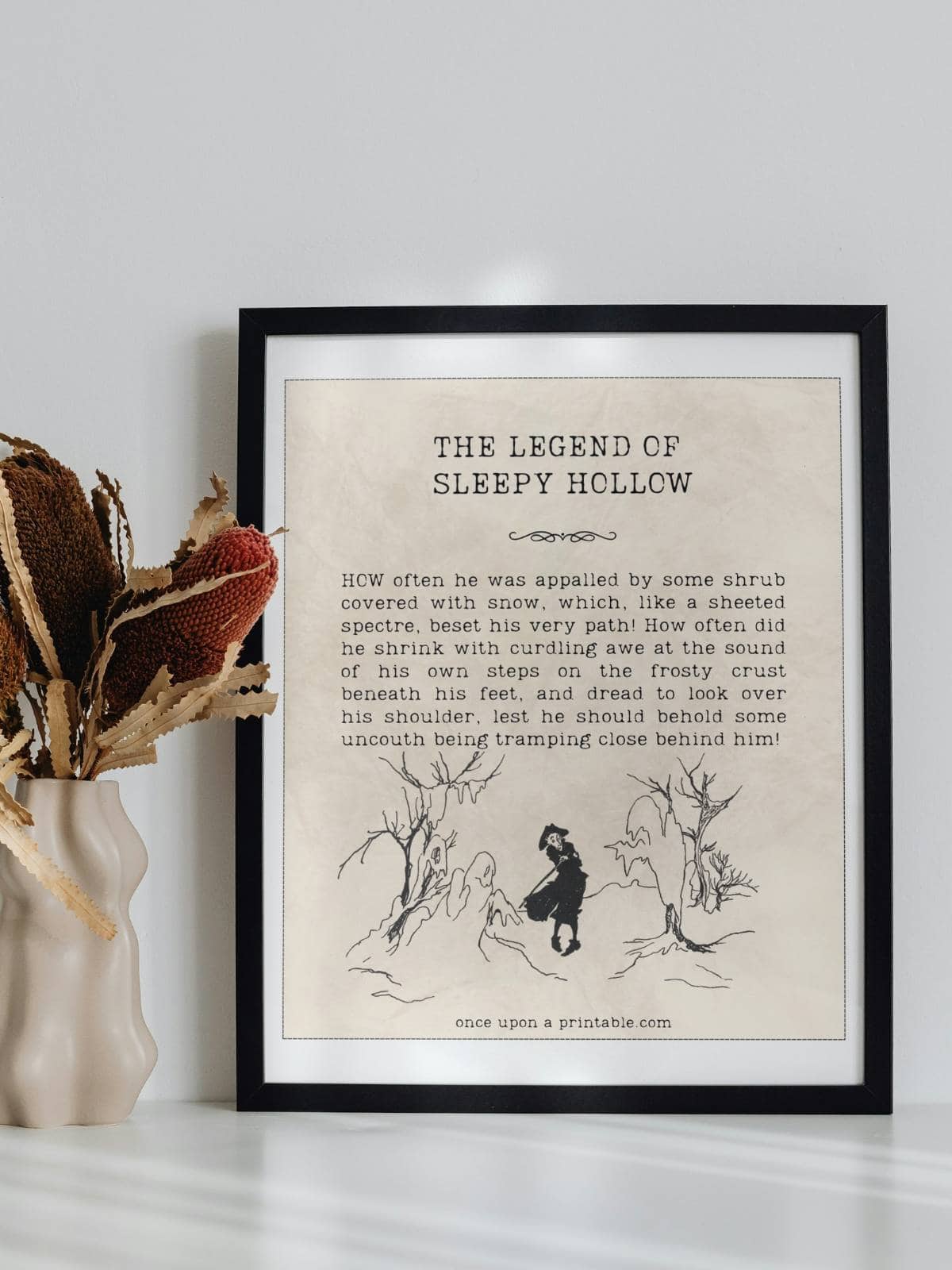 A quote from the book the Legend of Sleepy Hollow by Washington Irving framed and displayed next to a jar with dried flowers in it.