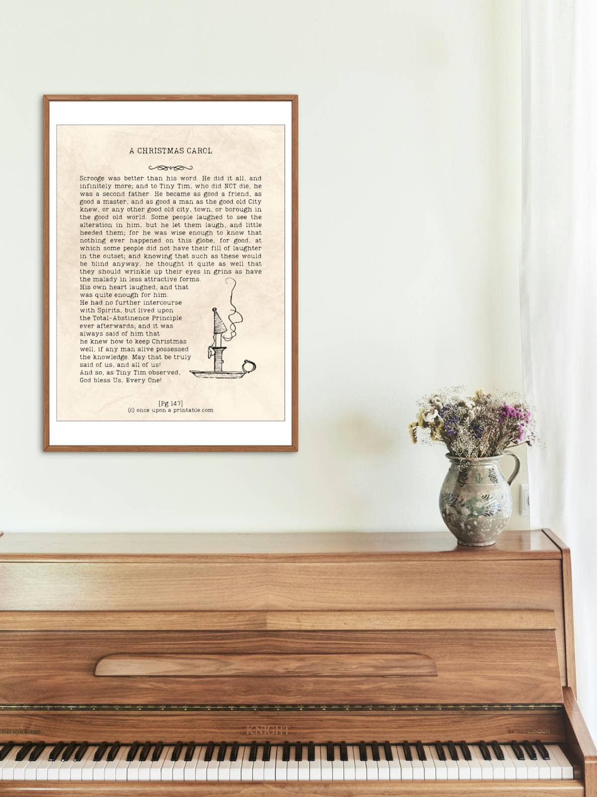 A christmas carol framed quote displayed above a piano.