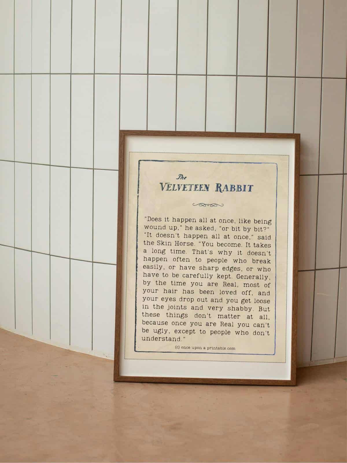 A quote from the book the velveteen rabbit framed and sitting against a tiled wall.