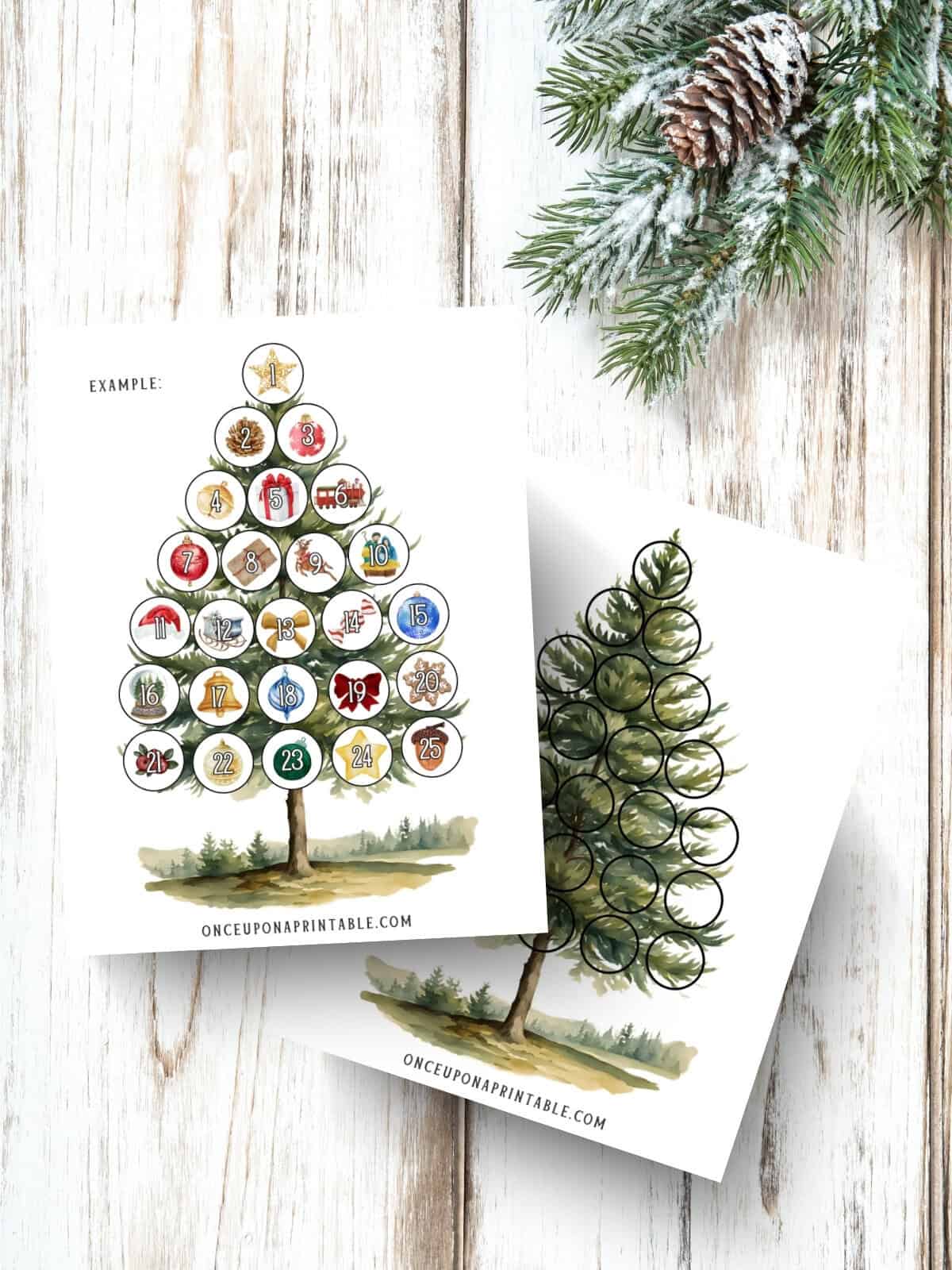 Example of a filled watercolor illustrated Christmas tree countdown and ornament sheet laying on a whitewashed wooden background with garland.
