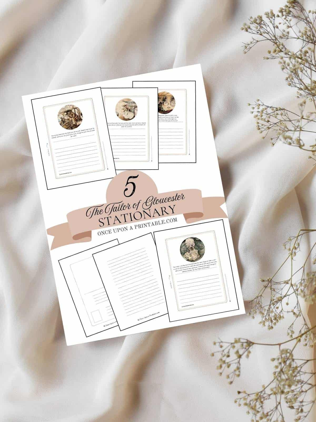 Cover page for 5 free the tailor of gloucester stationary sets laying on a white sheet with baby's breath flowers. 