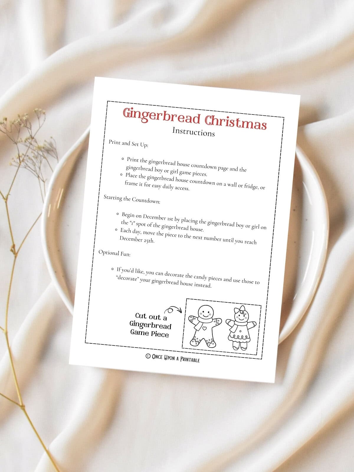 Gingerbread Christmas coloring activity instructions and the little gingerbread pieces as optional additions to the fun. The print out is sitting on a plate on a white table cloth with baby's breath flowers.