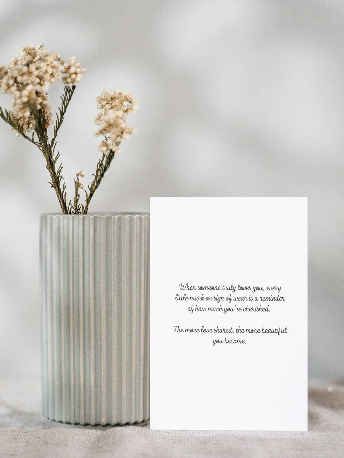 The inside of a note card with a sentiment, sitting next to a vase. 