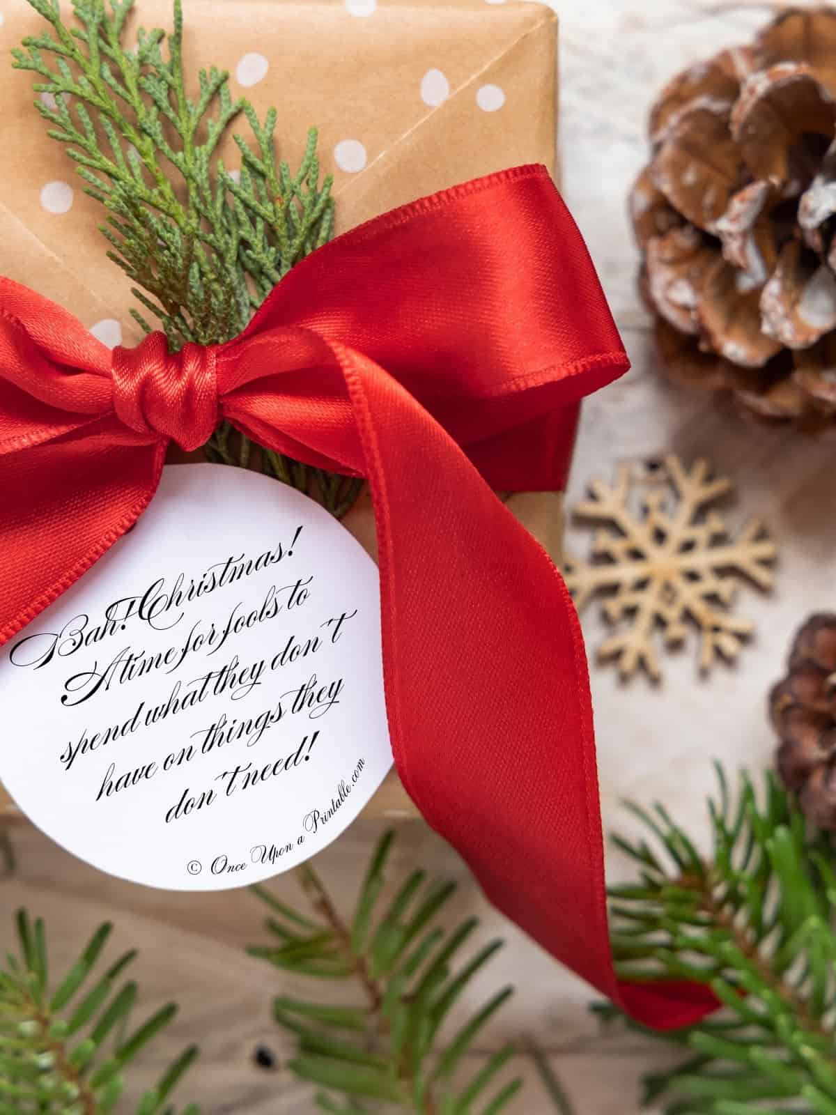 A Christmas Carol Scrooge sentiments for tongue-in-cheek christmas gift tag on a christmas present.