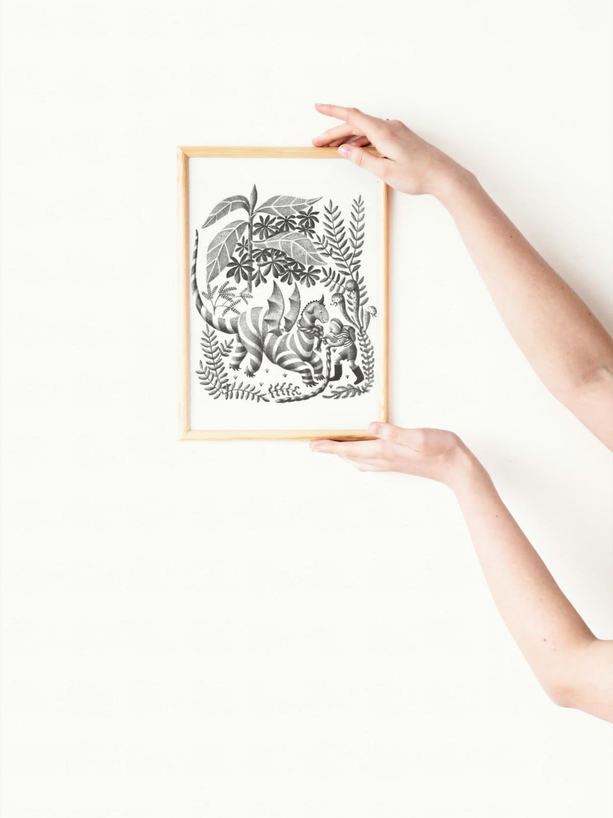 Framed original illustration (black and white lithograph) from the book my father's dragon behind held by a woman's hands.