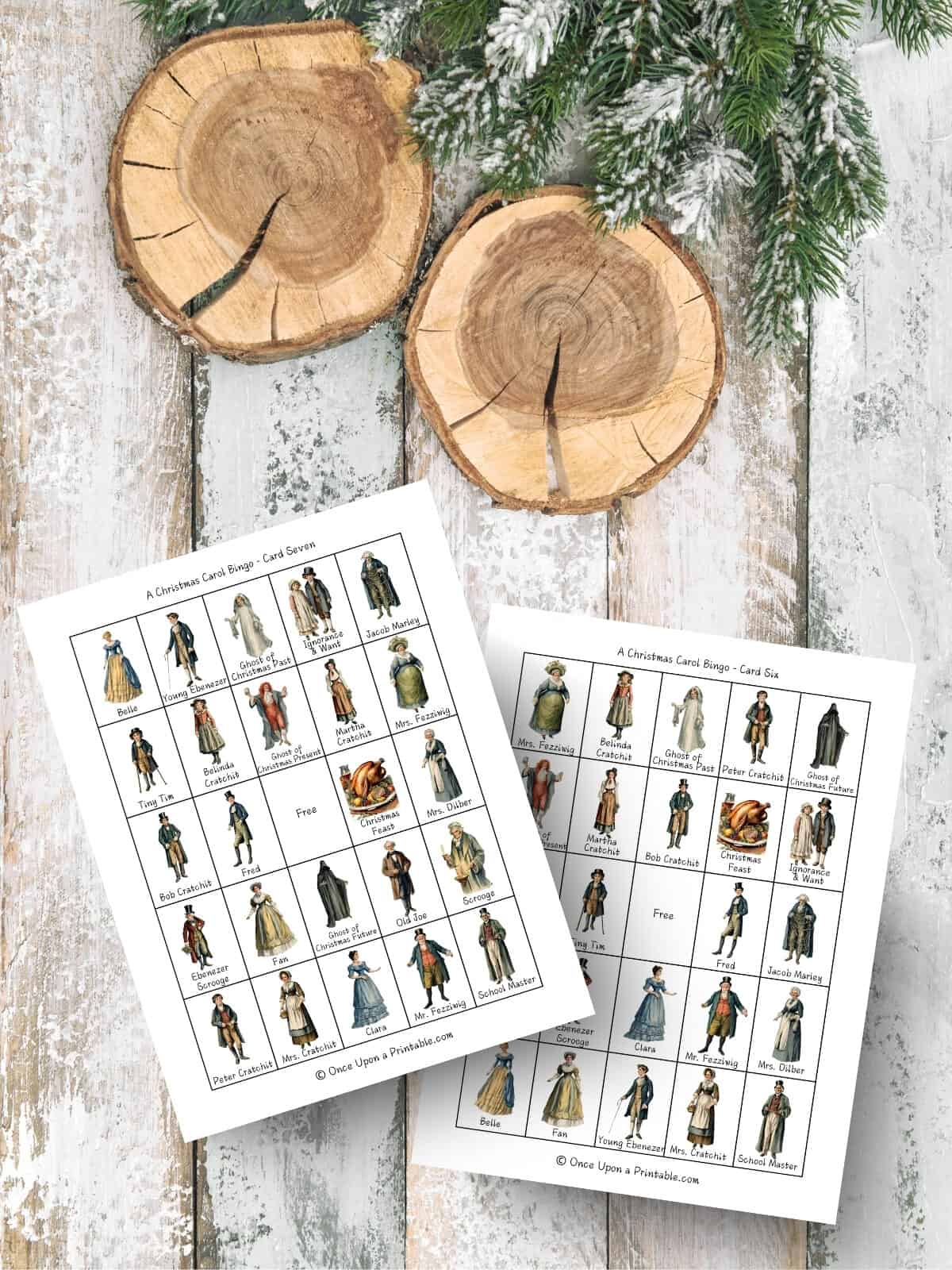 A Christmas carol themed bingo cards with watercolor graphics of the characters from the book, printed pages sitting on a wooden surface with log slices and garland.