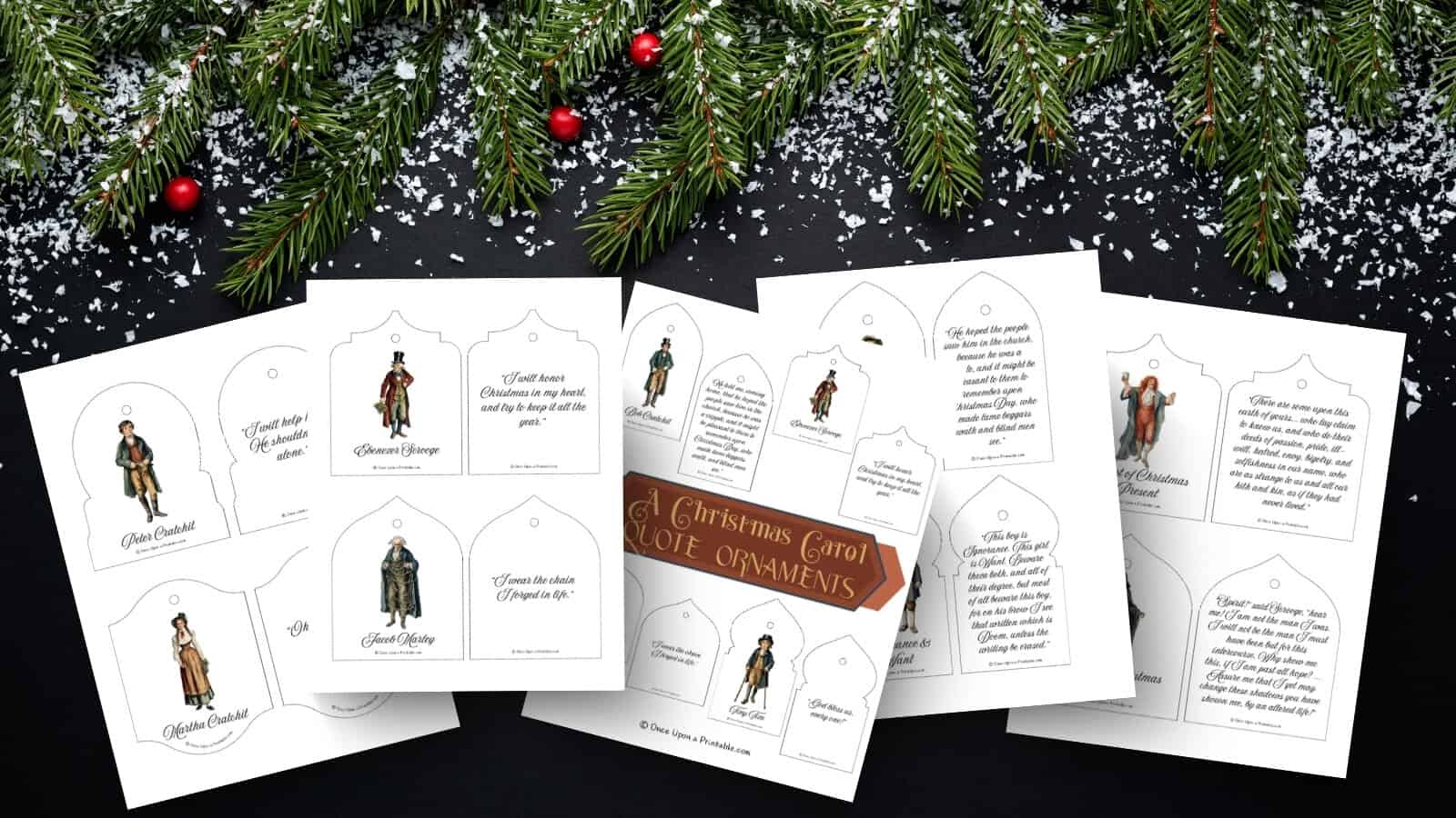 A Christmas Carol quote christmas tree ornament print outs laying on a dark background with fake snow and garland.