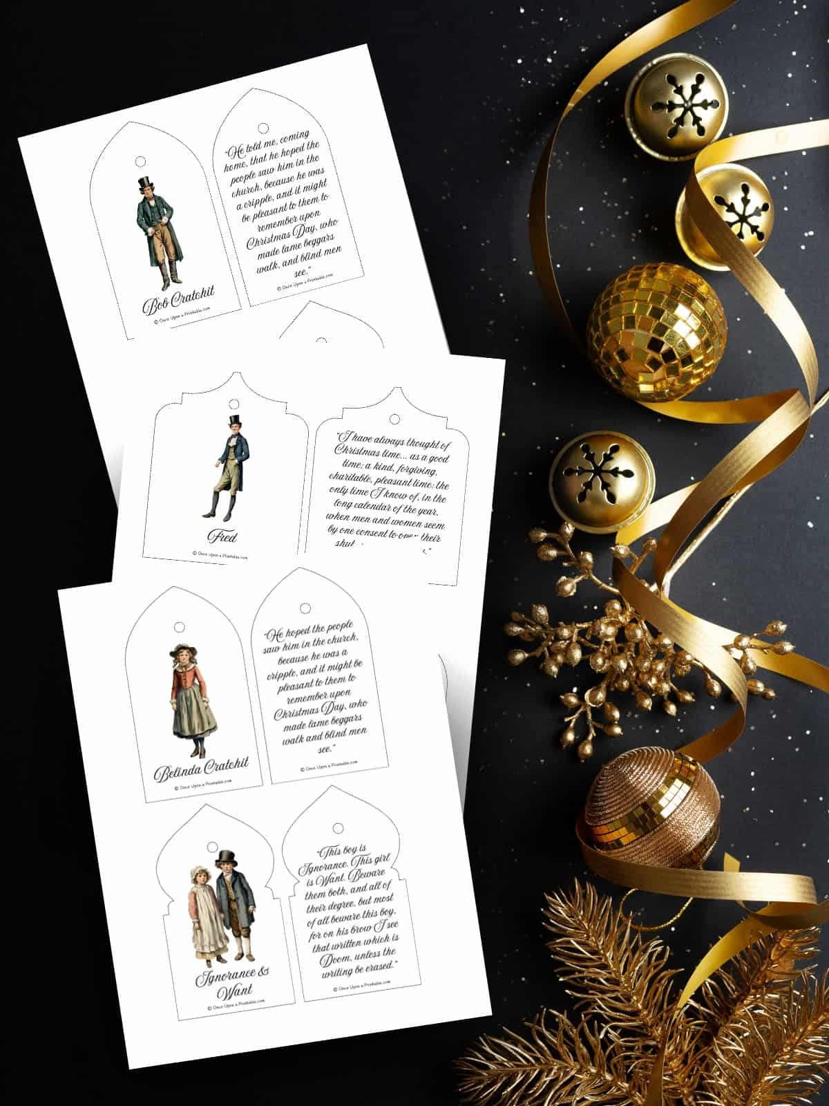 Charles Dickens quotes from "A Christmas Carol" with graphics of characters from the book printed out and laying on a dark background with golden bells and ribbon.