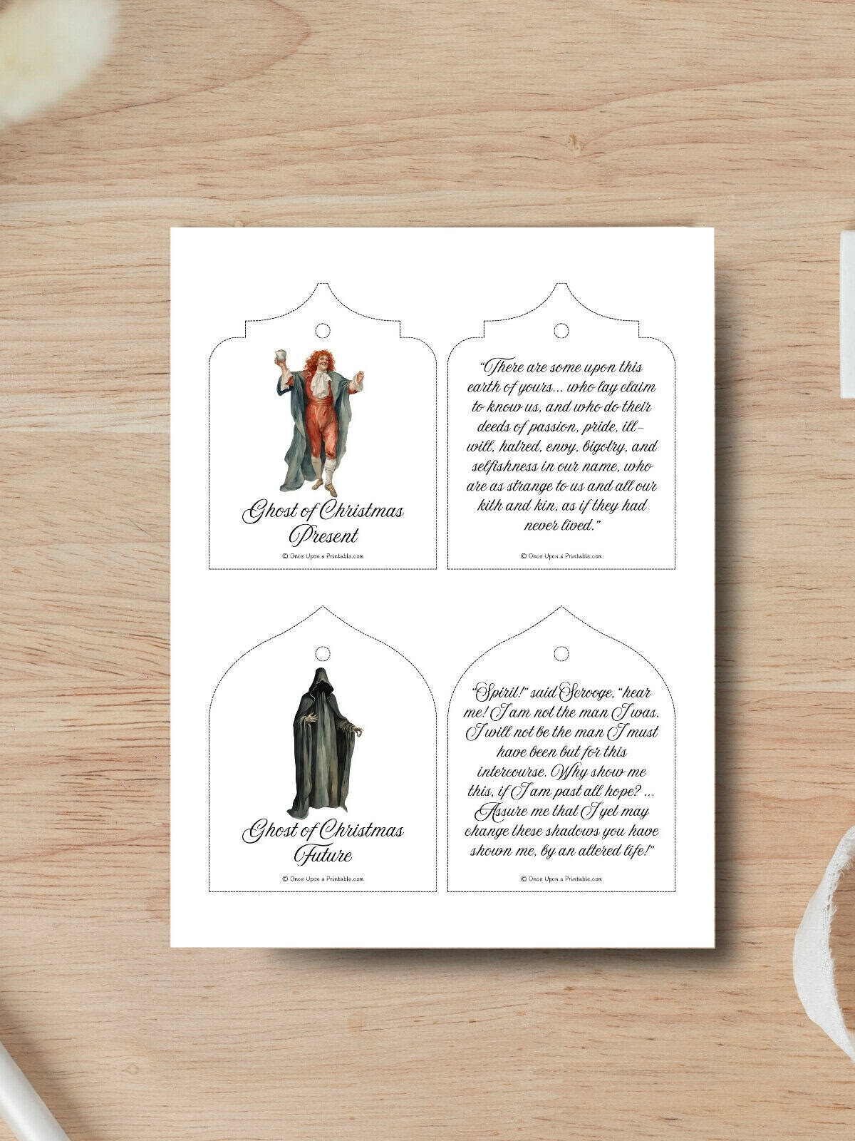 Quotes from the Spirit's of Christmas, Charles Dickens quotes and character images printed on a paper laying on a wooden surface.