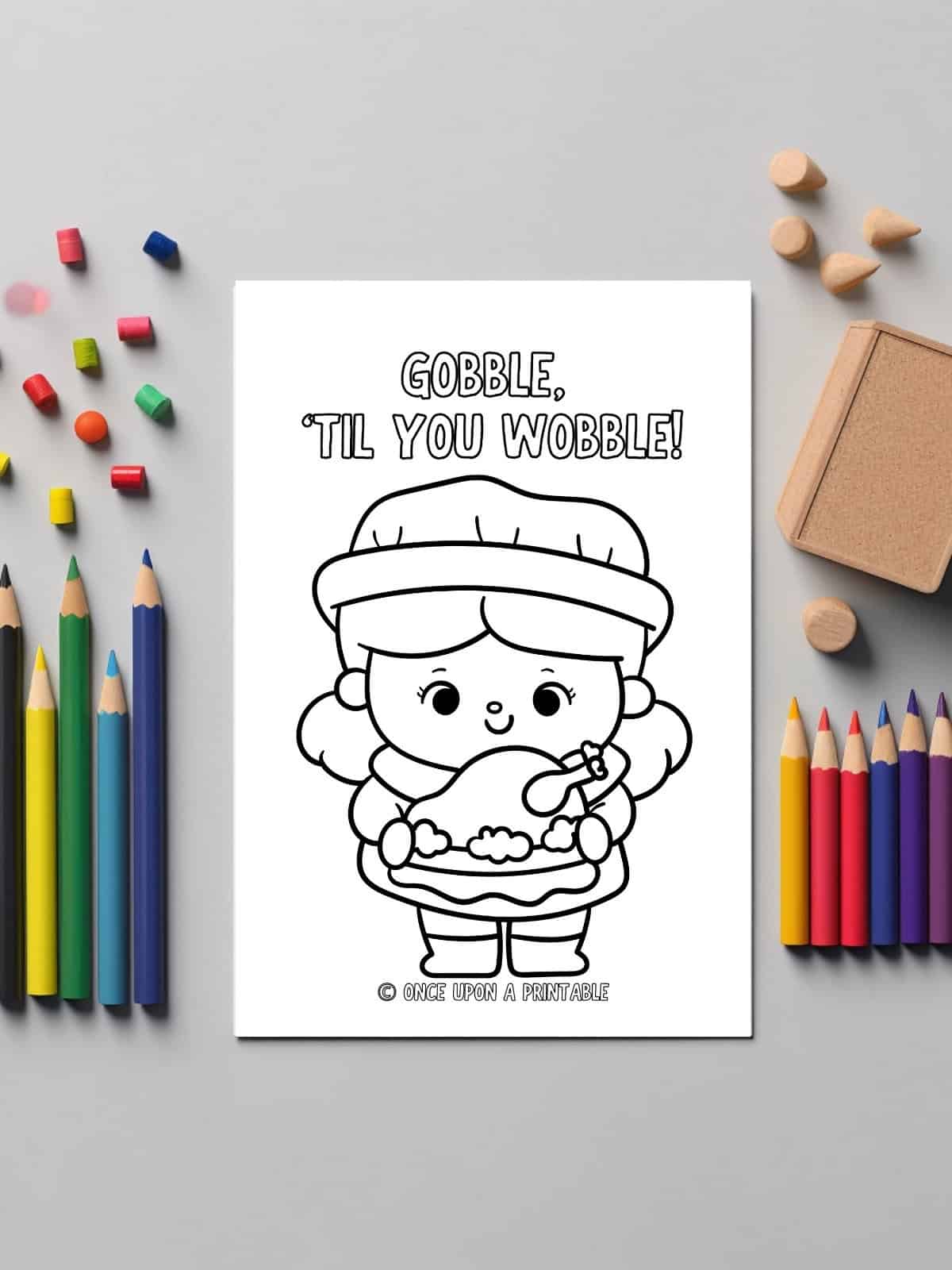 A little girl holding a turkey coloring page next to color pencils.