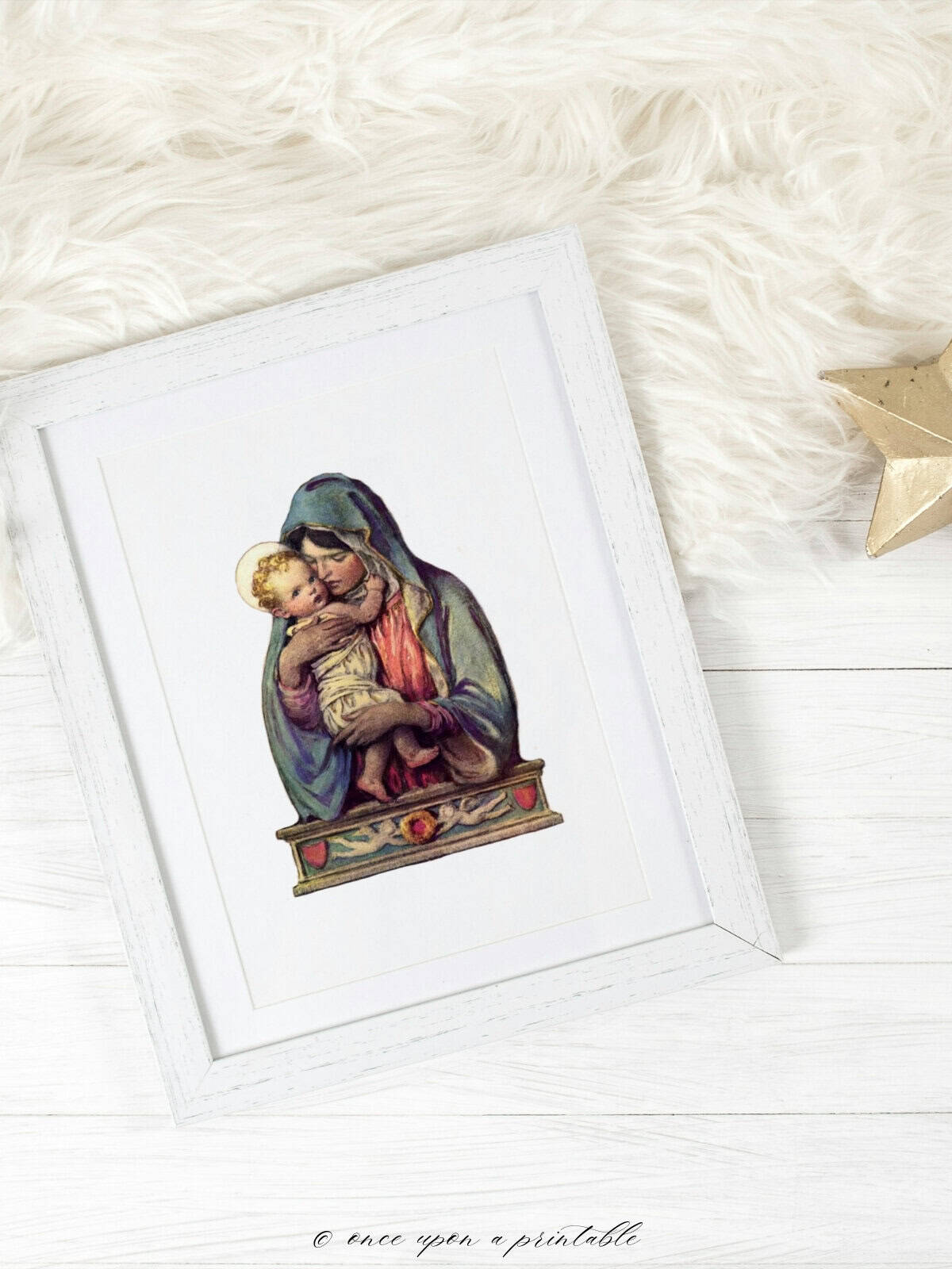 Vintage mary and baby jesus illustration framed and laying on a furry rug.