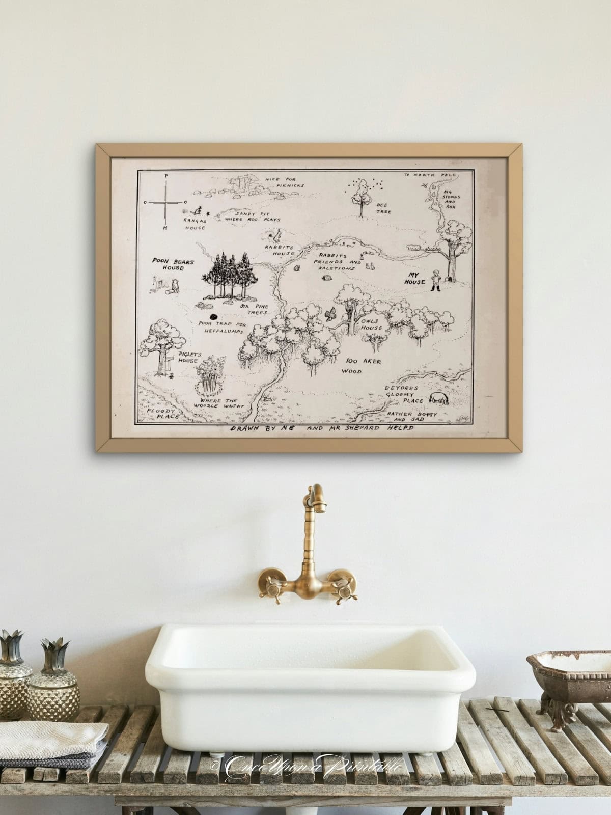 Classic 100 acre wood map framed and displayed above a sink in a bathroom.