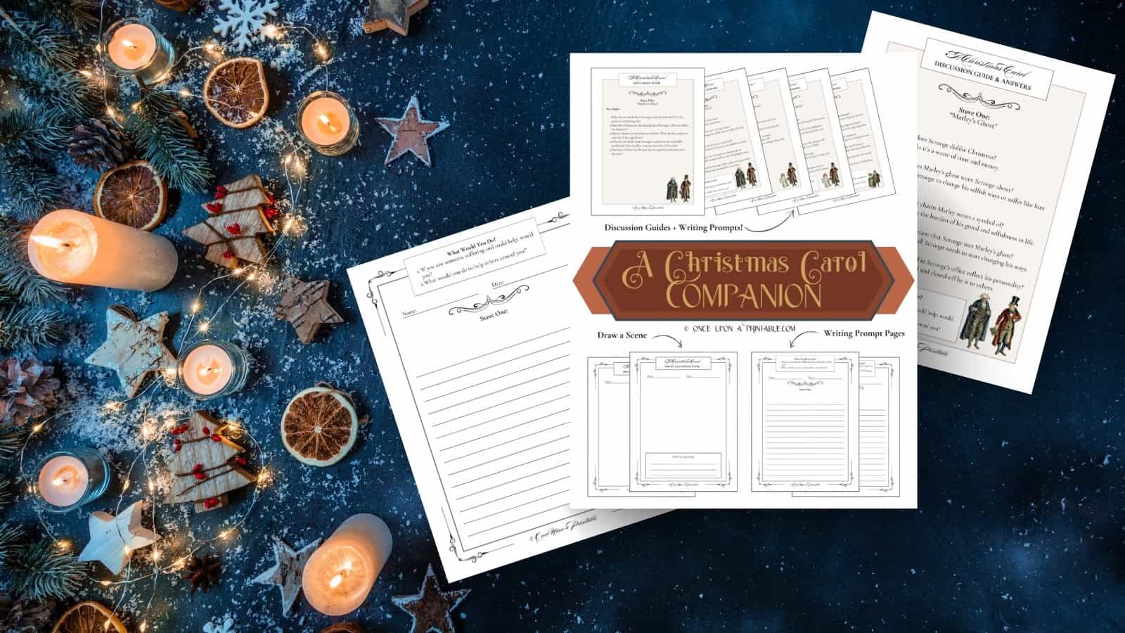 A Christmas Carol companion pages laying on a dark blue background with fake snow, dried oranges, cookies, and candles.