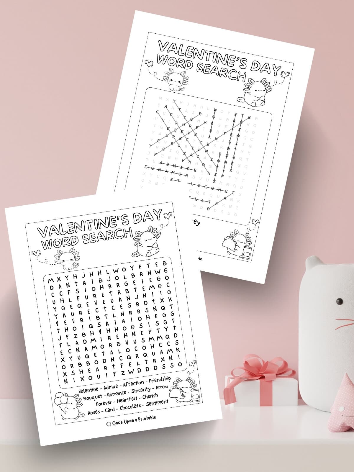 Axolotl Valentine's Day crossword puzzle and answer key laying on a pink background.