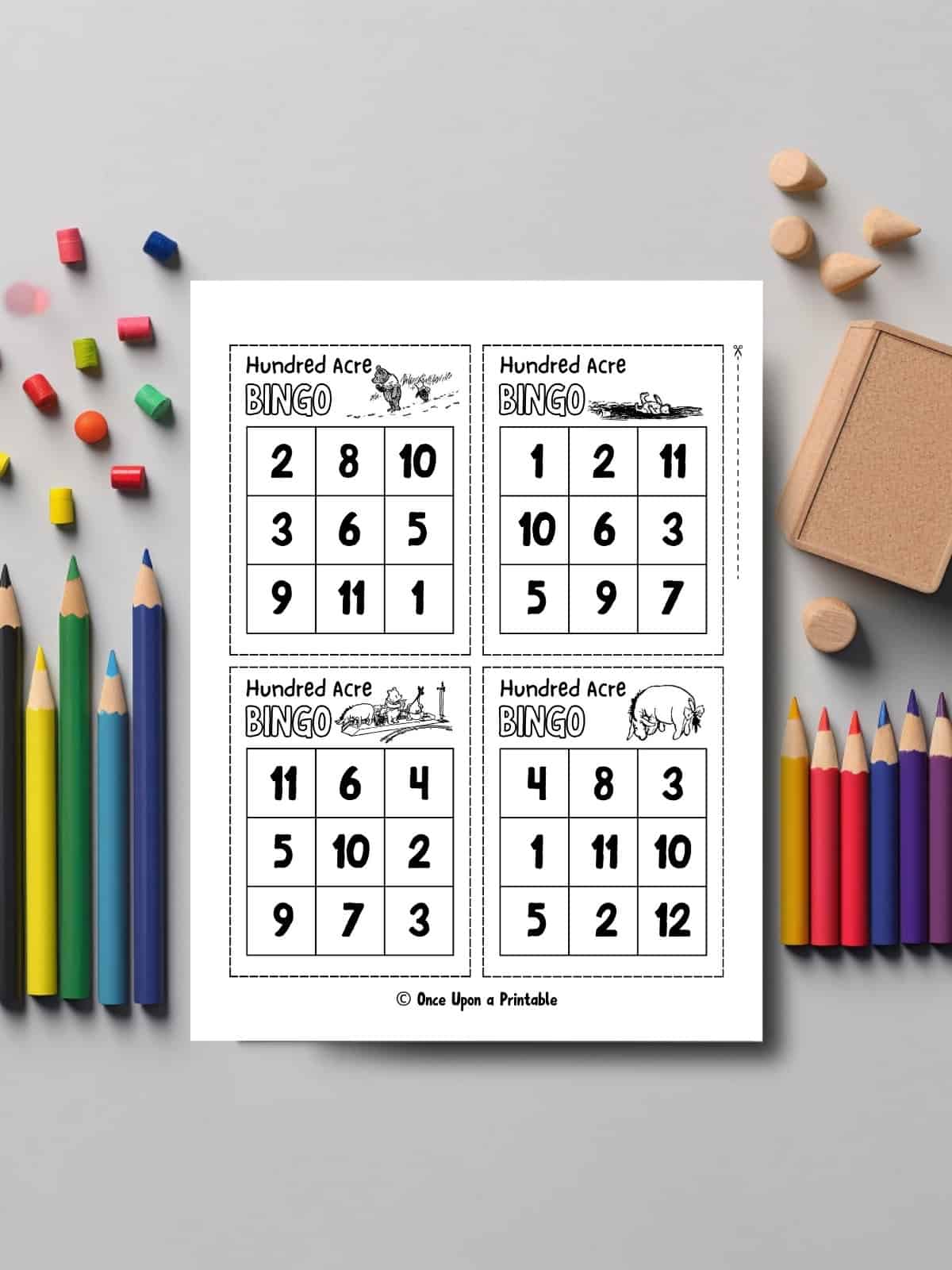 Classic hundred acre wood bingo game card laying on a table with coloring pencils.