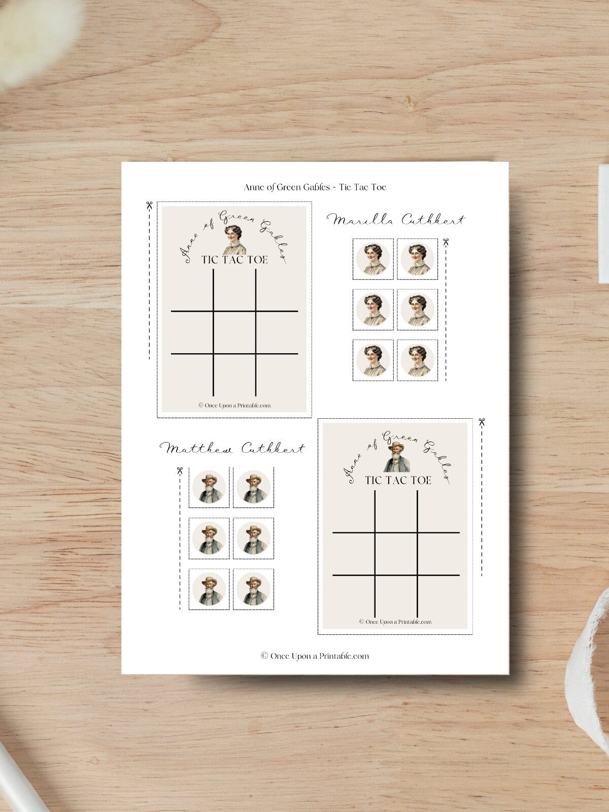 Marilla and Matthew Cuthbert tic tac toe cards laying on a wooden table.