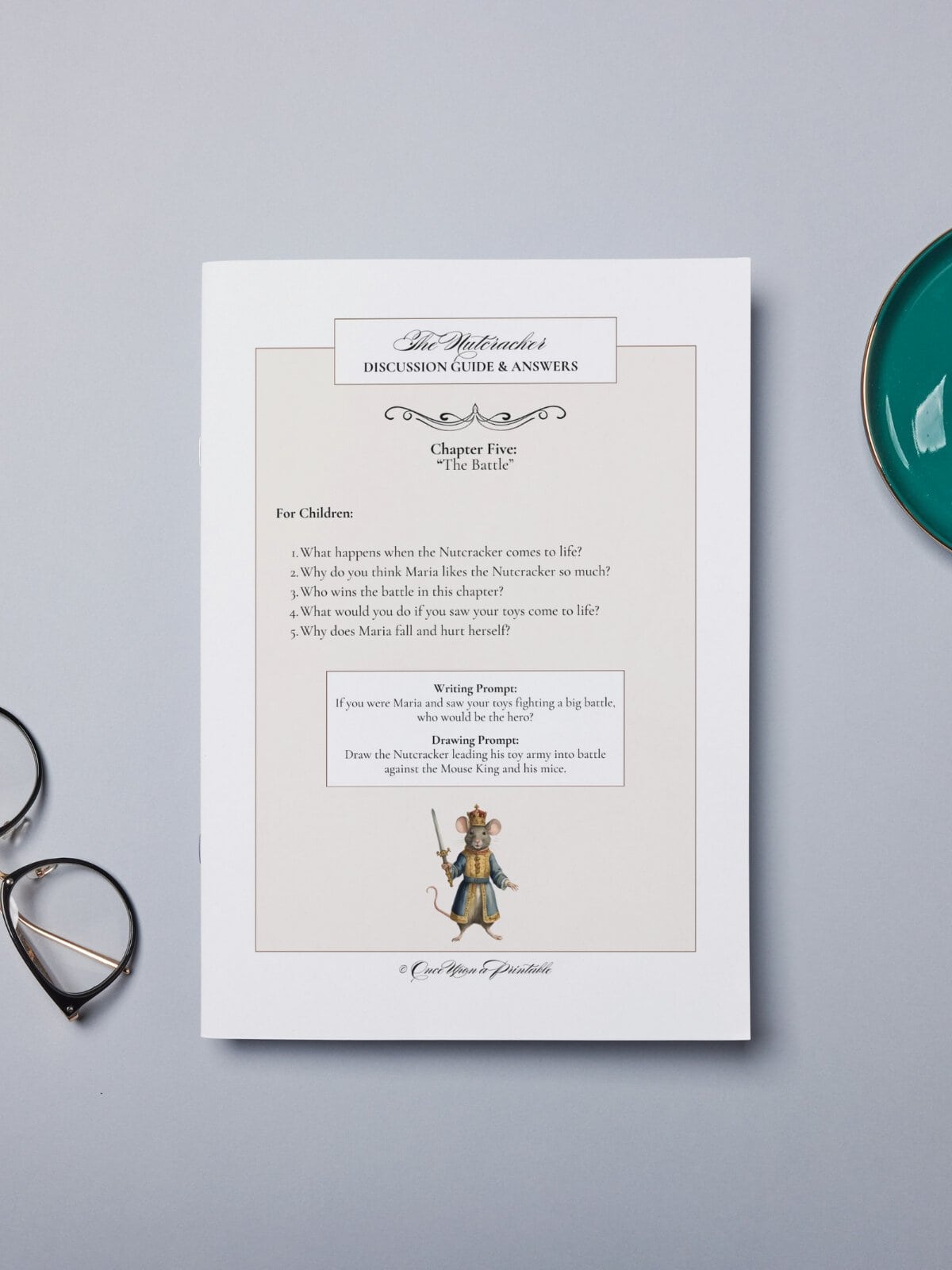 The nutcracker companion guide printed and laying on a table top with glasses and a cup.