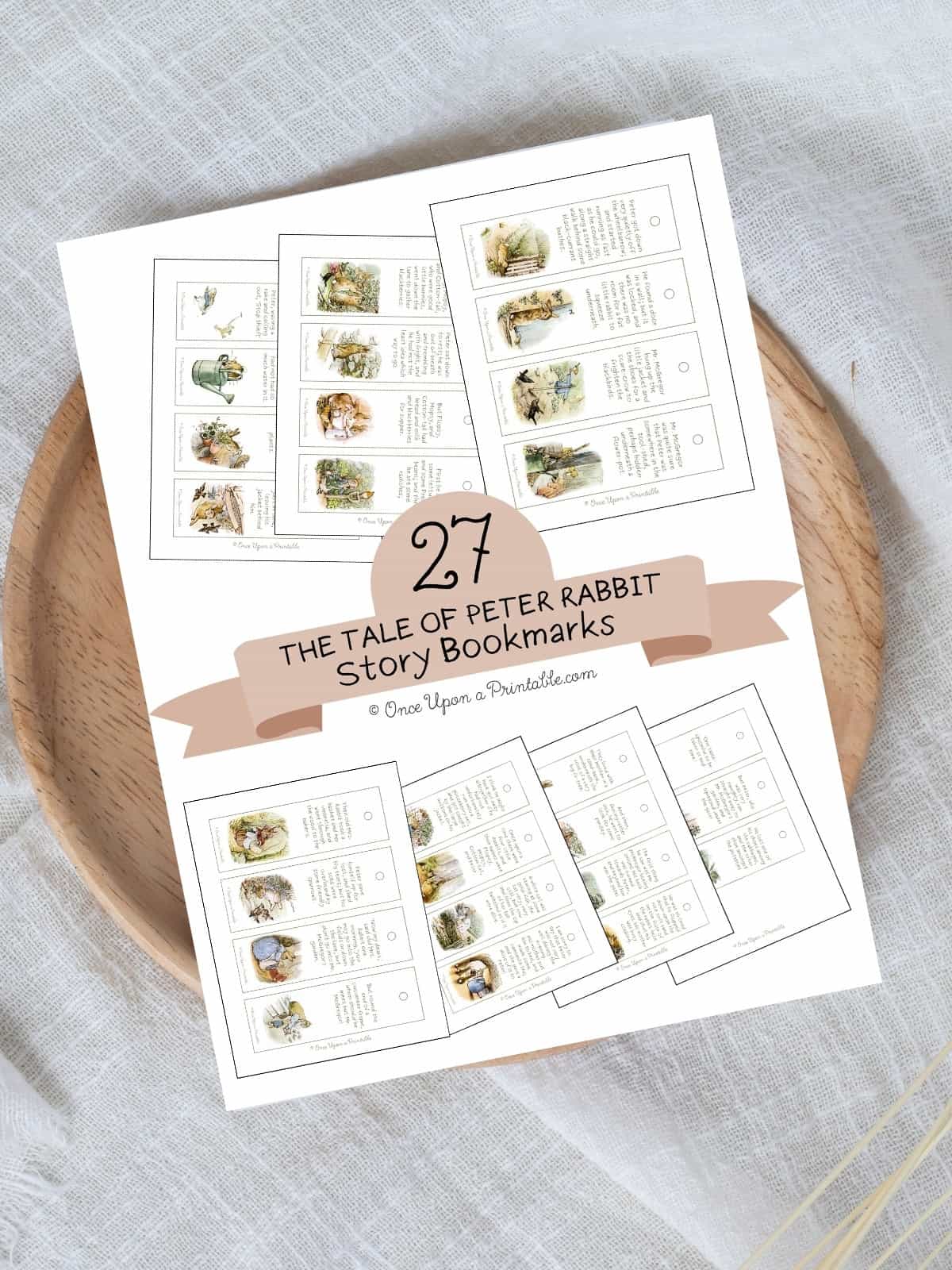 The cover page for the 27 illustrated peter rabbit bookmarks laying on a wooden lazy susan.