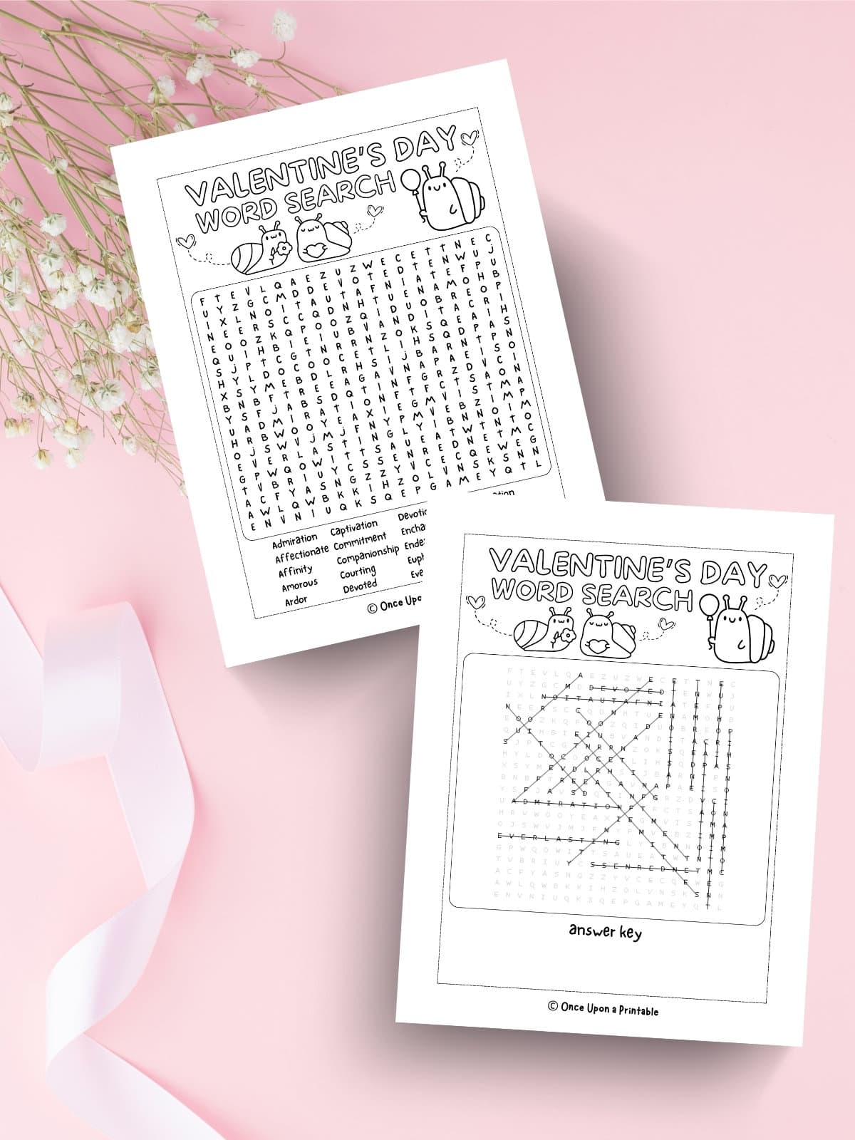 A snail themed crossword puzzle for Valentine's Day on a pink background with baby's breath flowers and a ribbon.