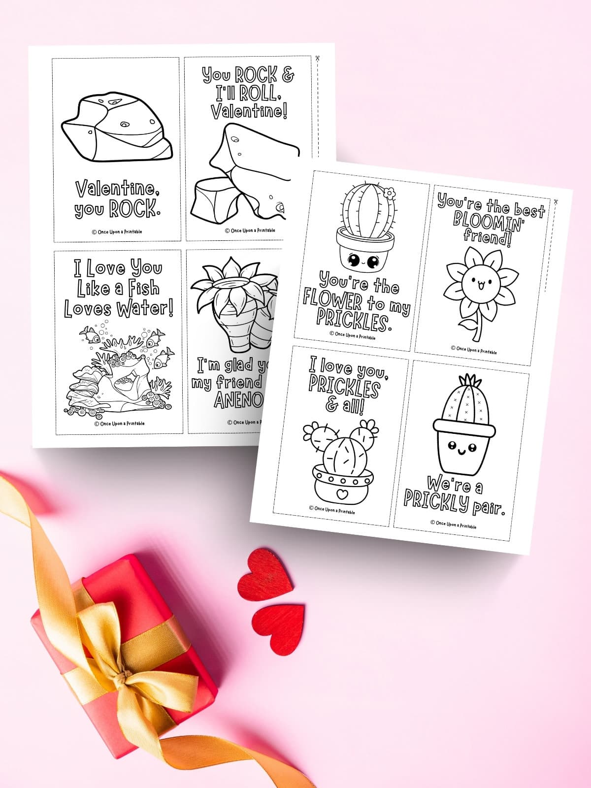 Valentine's day cards for kids to color laying on a pink background with a gift.