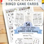 Peter Rabbit illustrated bingo cards laying on a wooden table with coloring pencils and crayons.