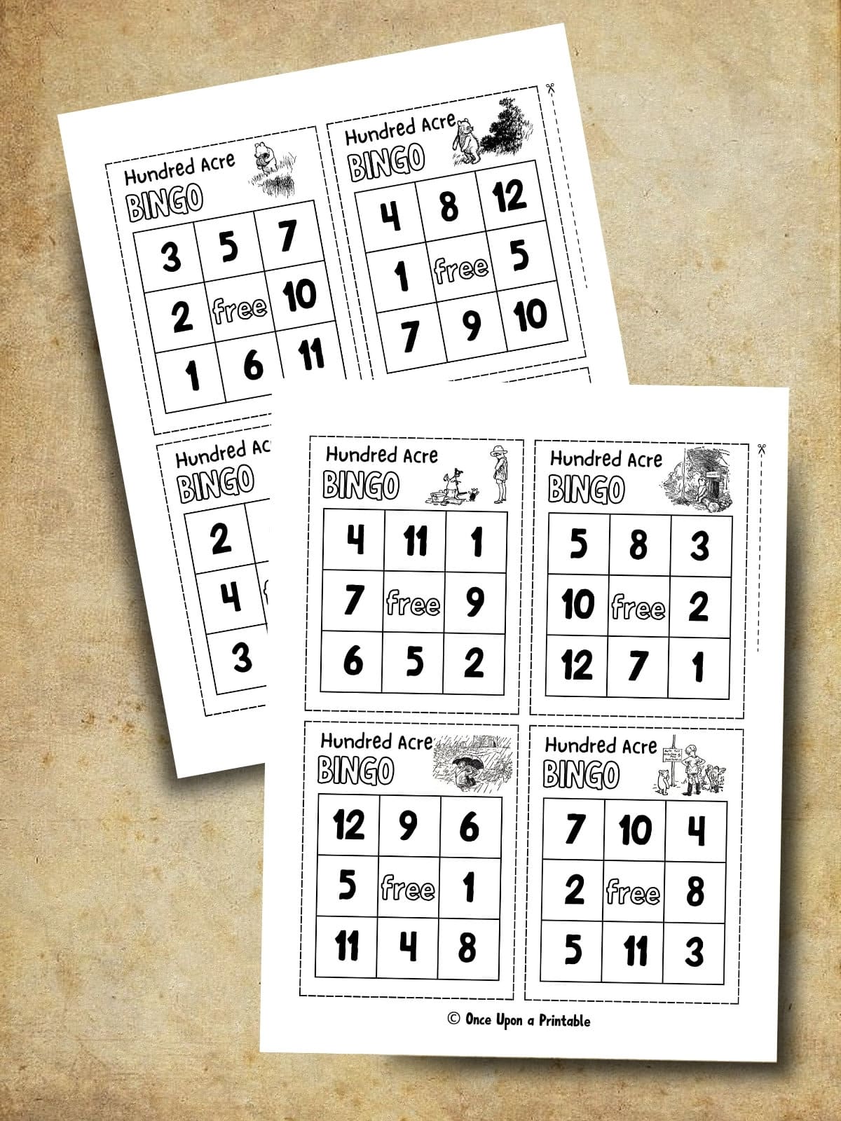 Winnie the Pooh illustrated bingo cards laying on a brown paper surface.