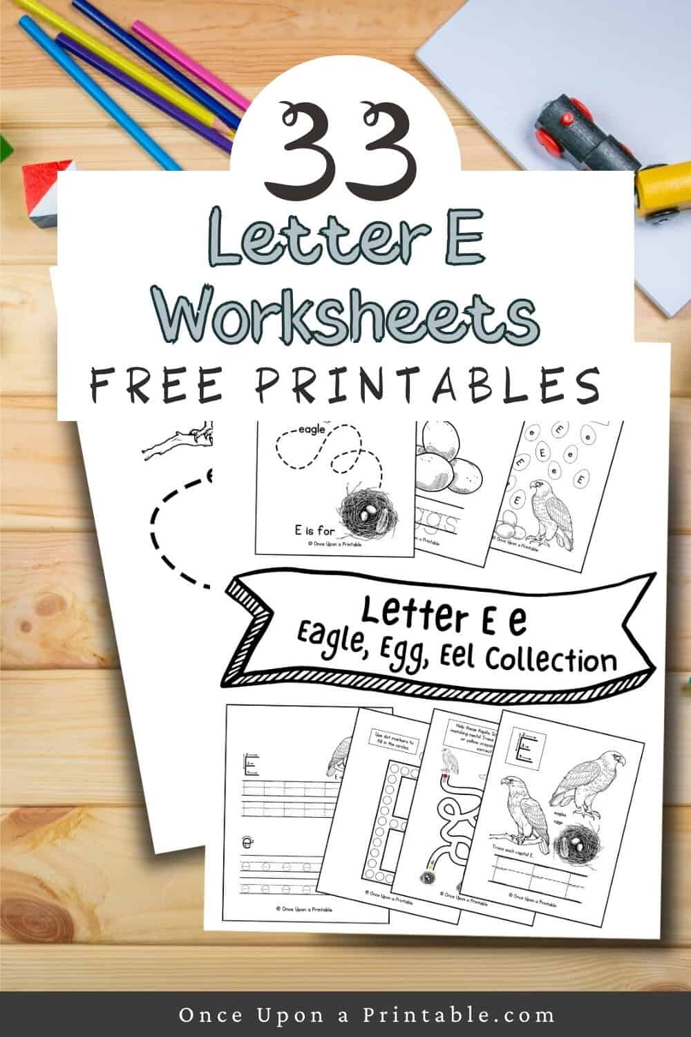 Letter E eagle egg and eel worksheets laying on a wooden table with coloring pencils.