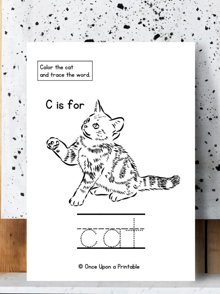 C is for Cat word tracing and coloring page laying on a speckled background.
