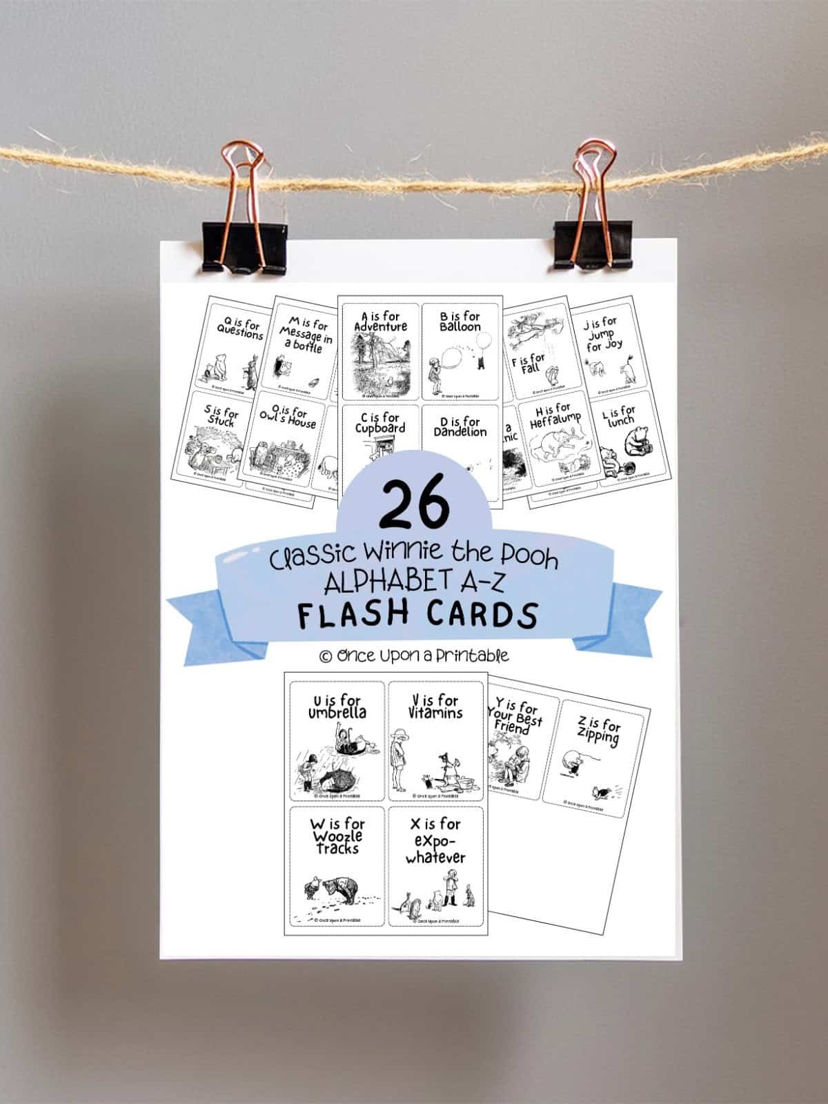 Classic Winnie the Pooh Alphabet cards cover page hanging on a rope with two bull clips.