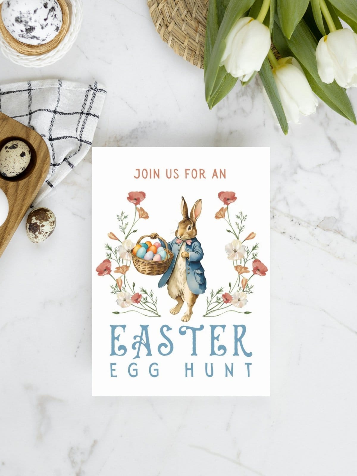 Easter egg hunt invite card with peter rabbit laying on marble top with tulips and eggs.